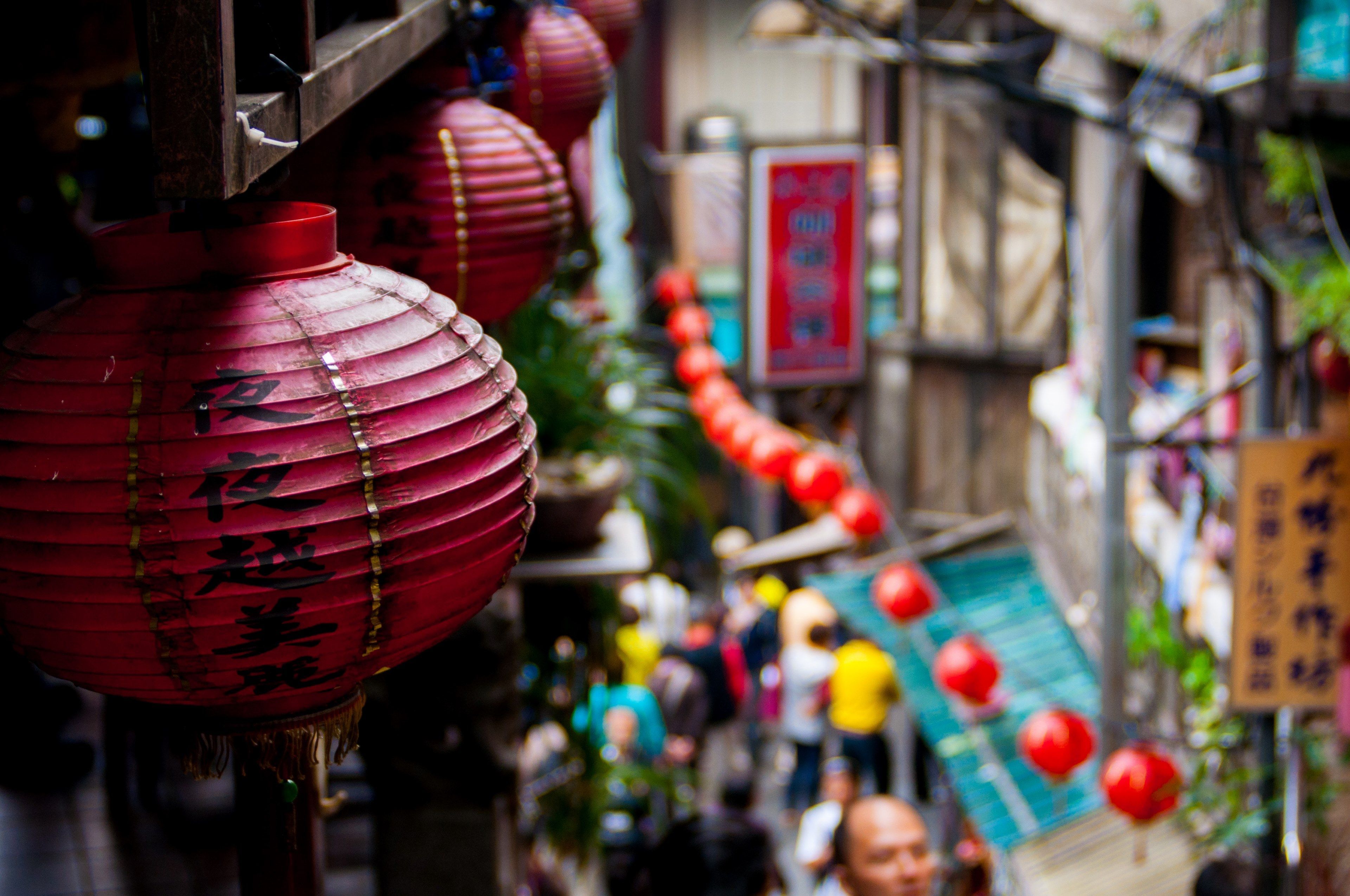 3840x2550 Wallpaper / the macro view of chinese lanterns placed on walls and a blurry view of people walking in a market road in jiufen old street, _chinese lanterns in market