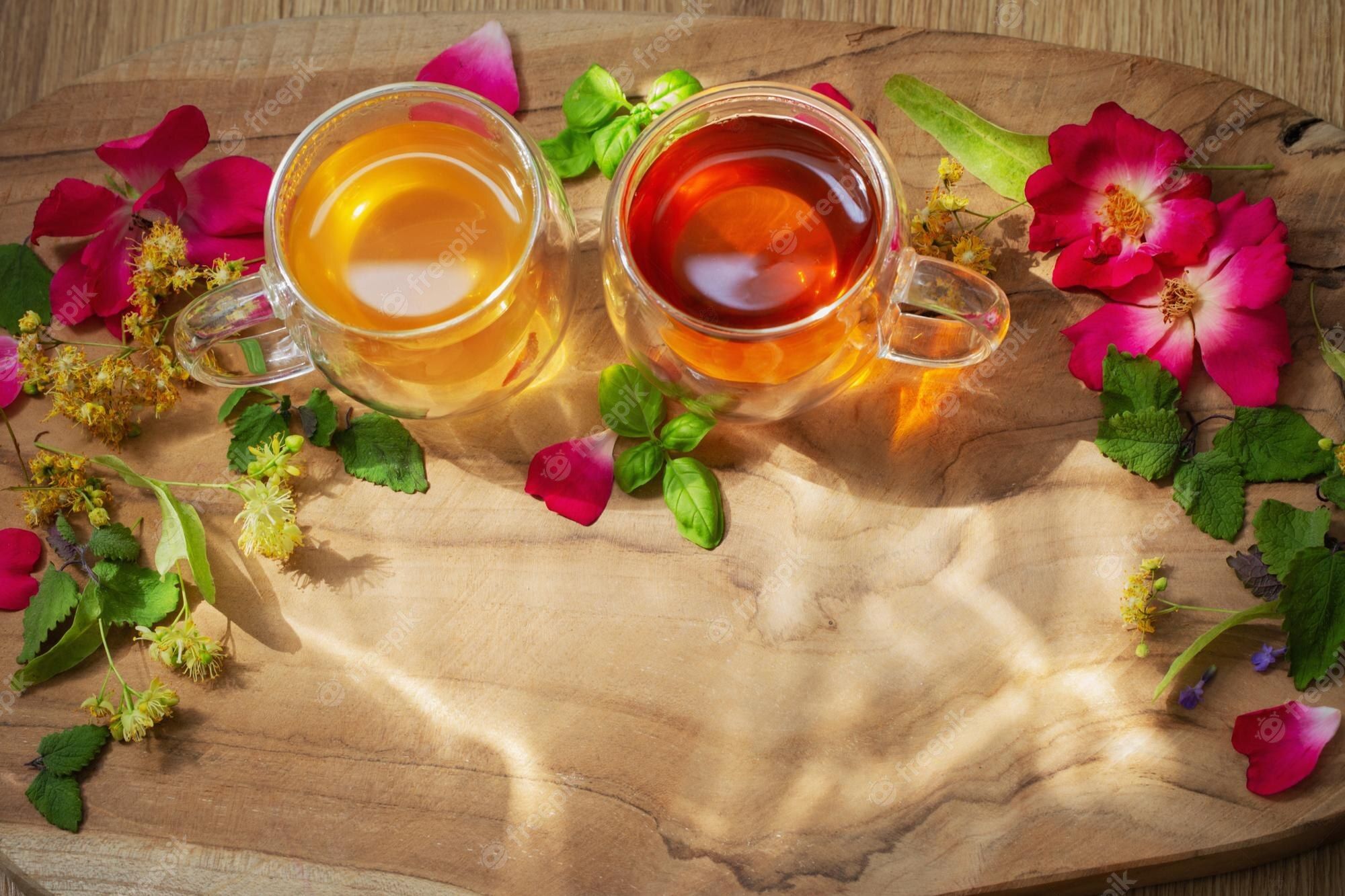 2000x1333 Premium Photo. Herbal tea in glass cups with flowers and herbs on wooden background