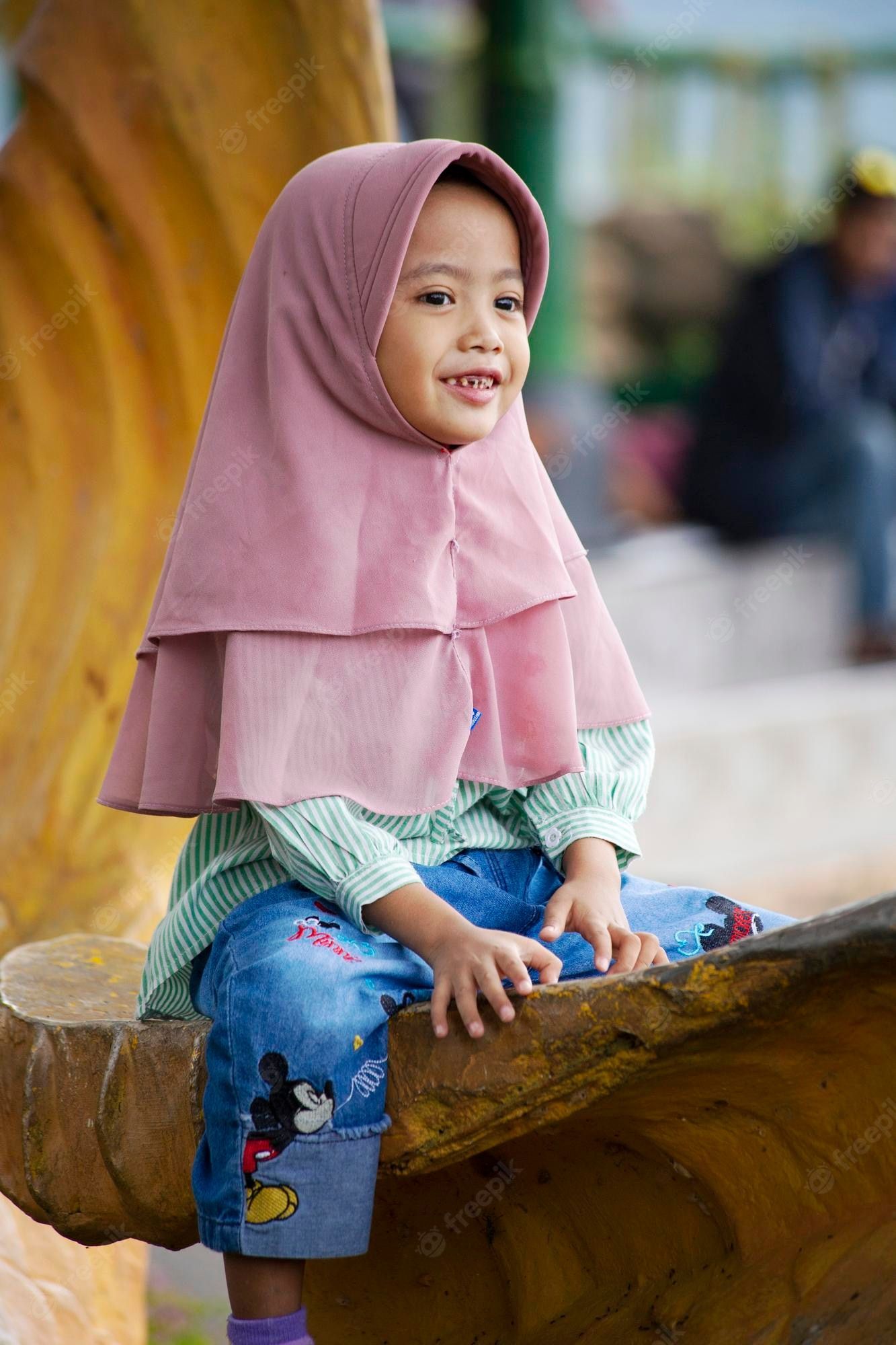 1333x2000 Premium Photo. Pink cutcute indonesian muslim girl wearing hijab smiling for camera on the children cockatoo parrot
