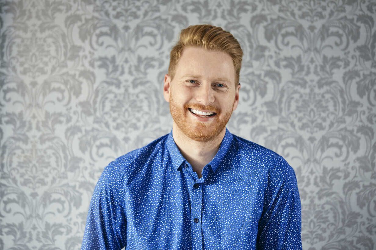 1232x821 Portrait of a happy man in front of patterned wallpaper