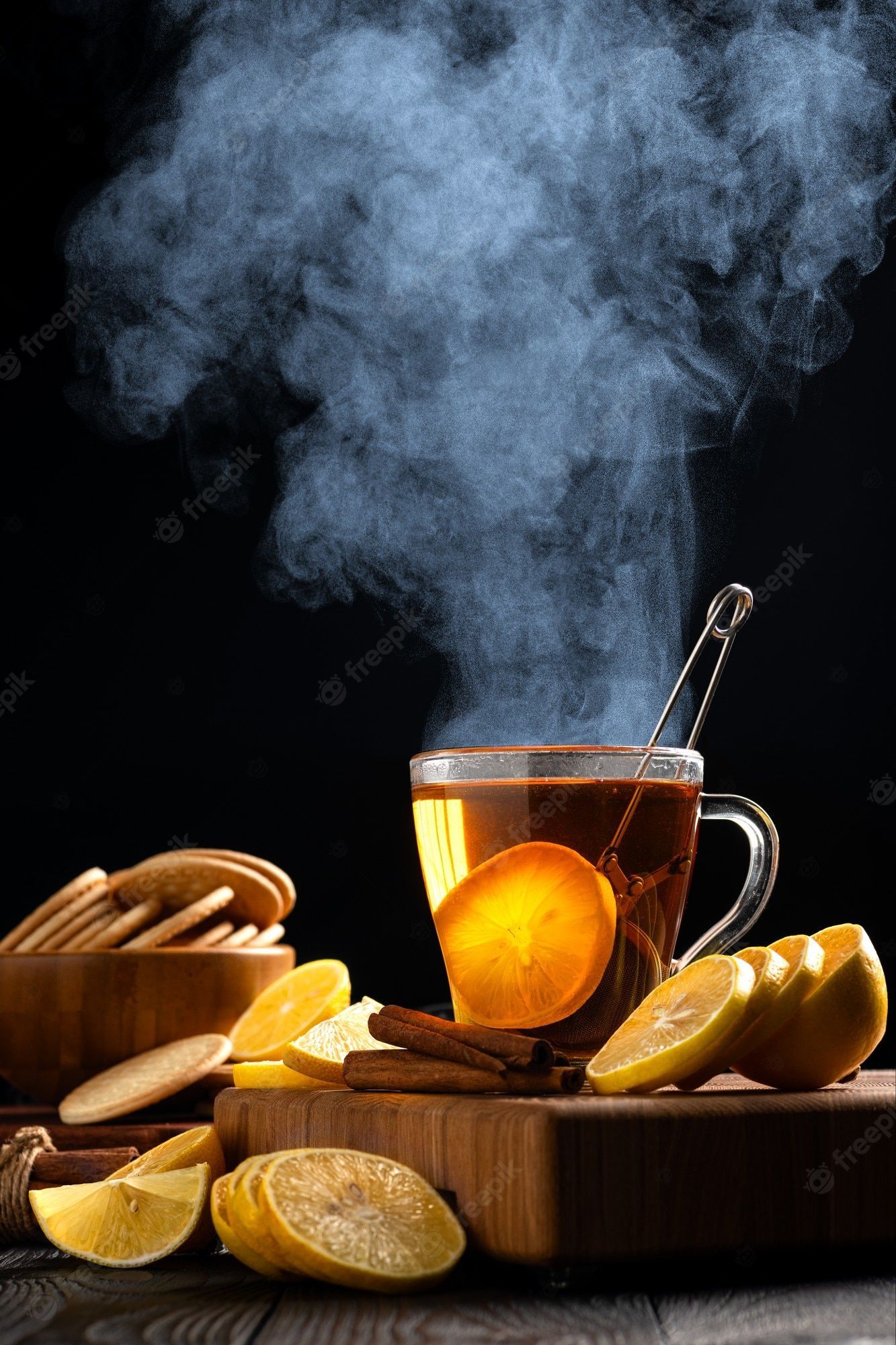 1333x2000 Premium Photo. Still life with hot tea and lemons, dense steam rises above