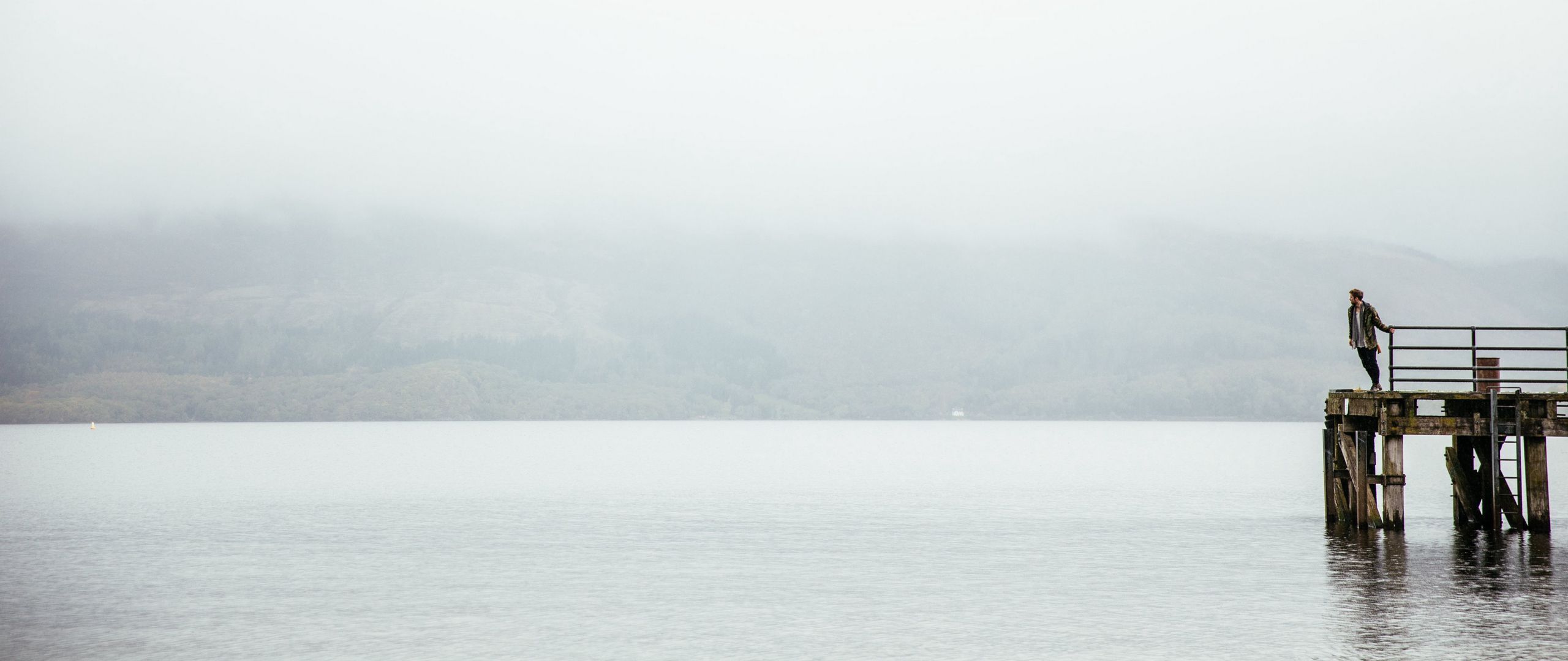 2560x1080 Download wallpaper 2560x1080 pier, man, loneliness, melancholia, lake, fog, water dual wide 1080p HD background