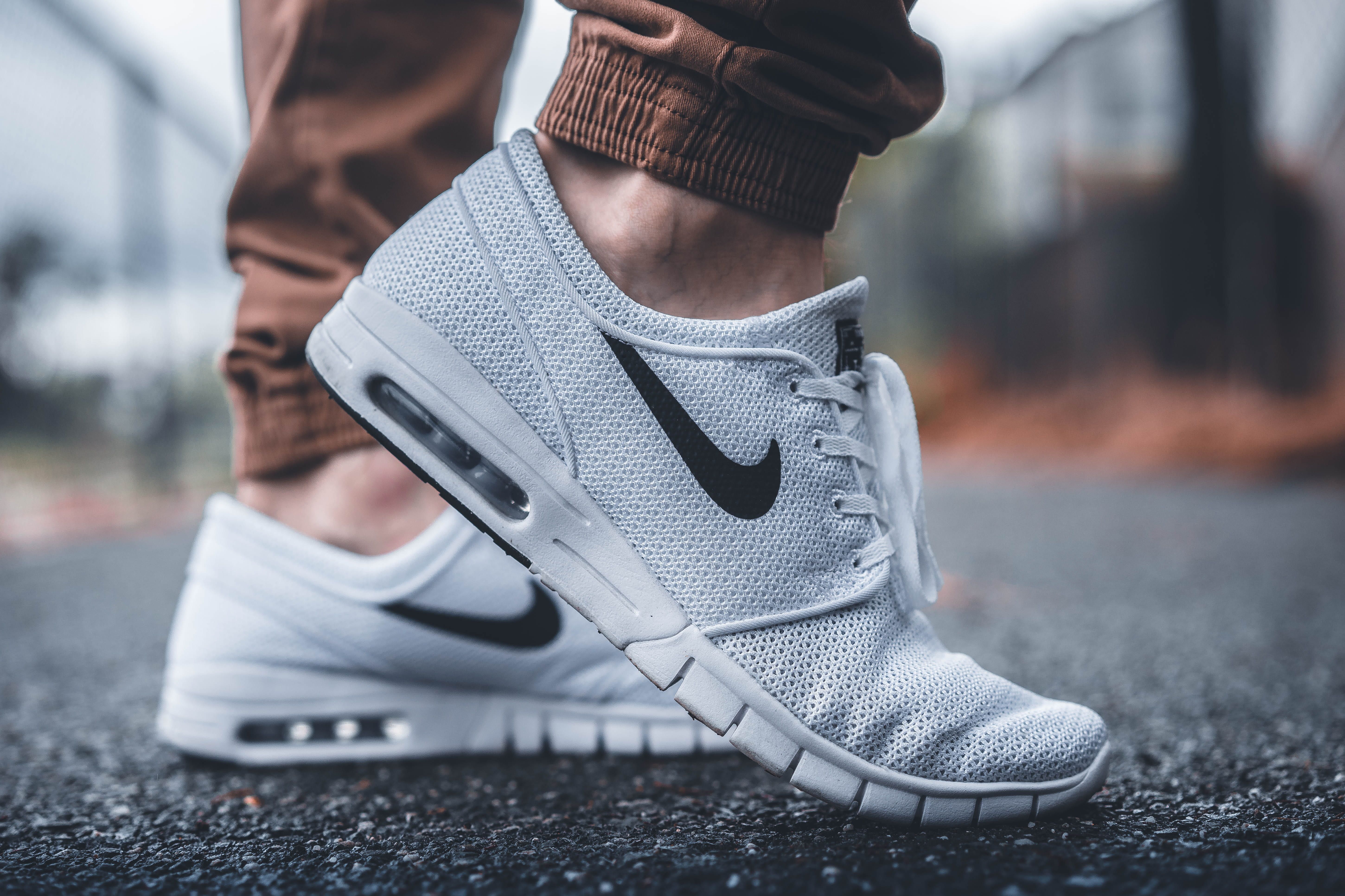 5801x3867 Wallpaper Person Wearing White Nike Running Shoes Standing On Black Concrete Path, Person Wearing White Nike Sneakers