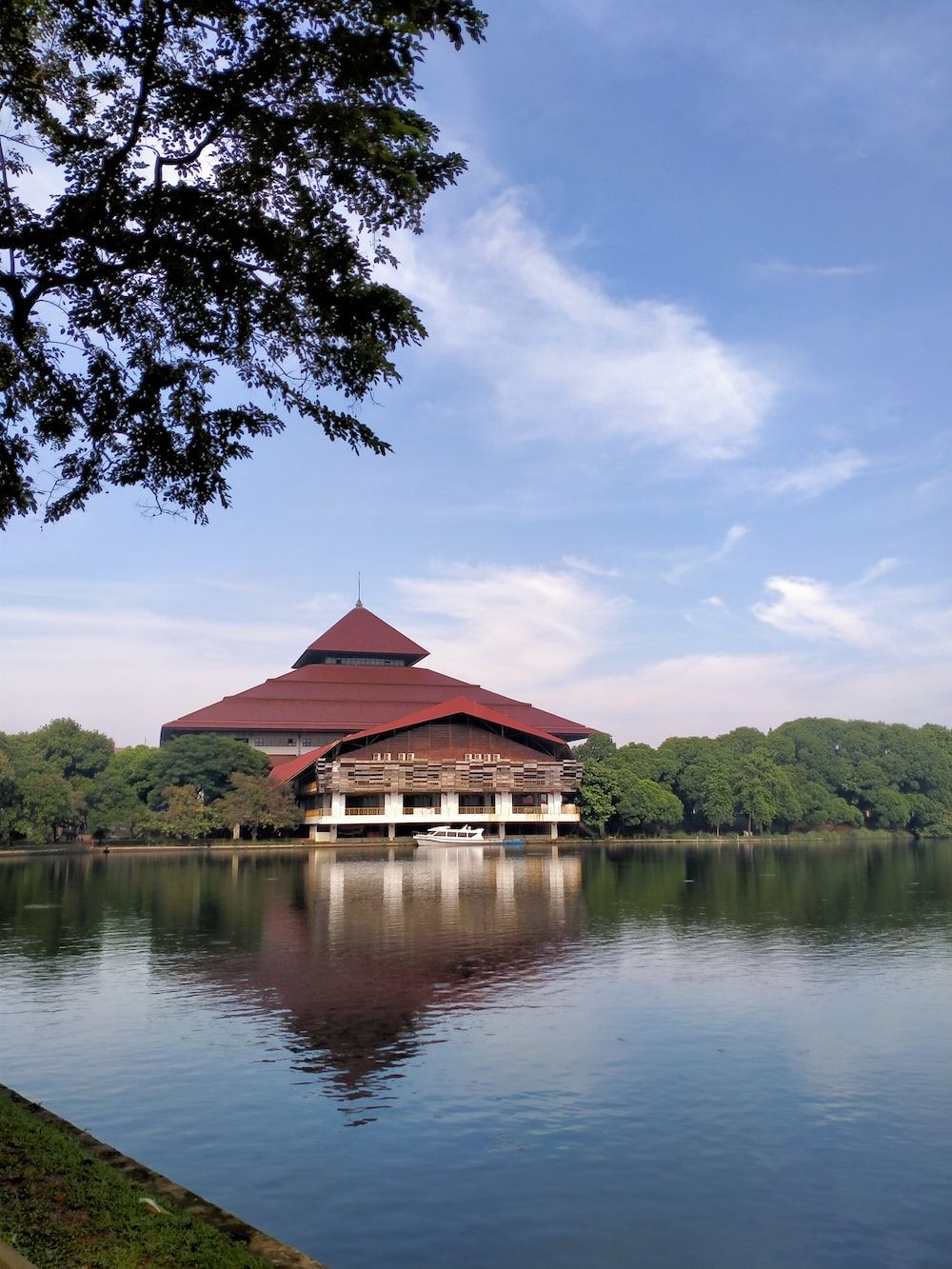 1000x1333 Brown wooden house on lake near green trees under blue sky during daytime photo
