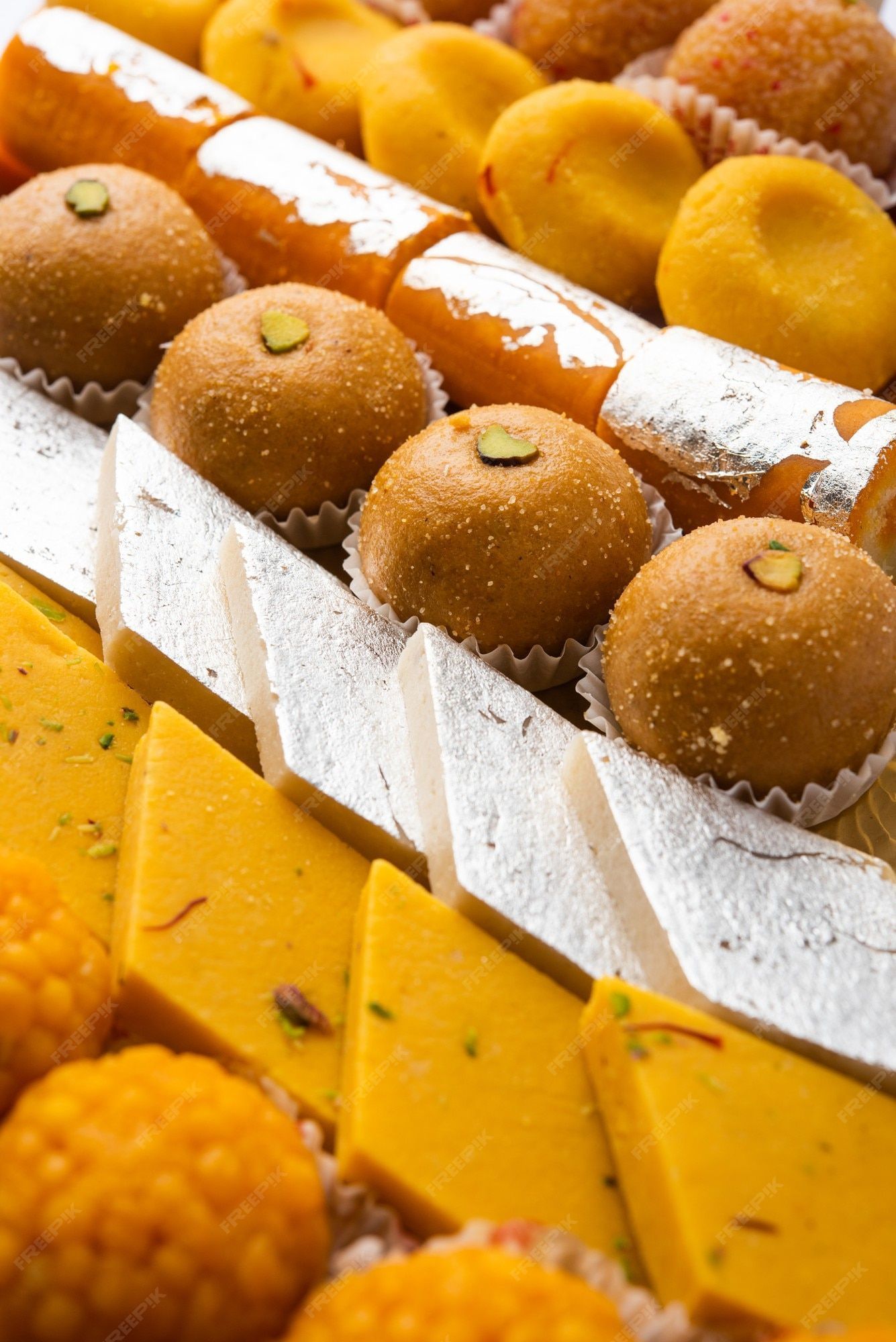 1335x2000 Premium Photo. Group of indian assorted sweets or mithai with diya