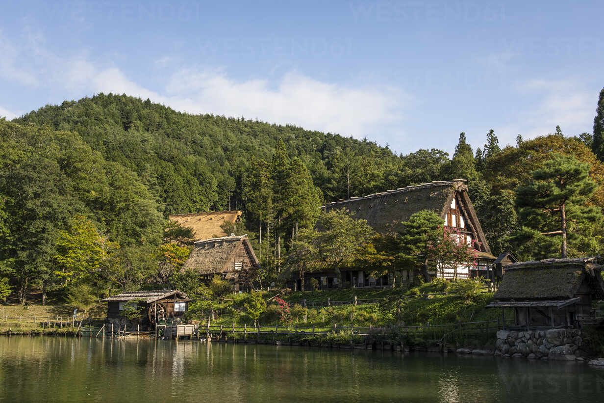 1232x821 Japan, Takayama, Historical Hida Folk Village with forested hill in background