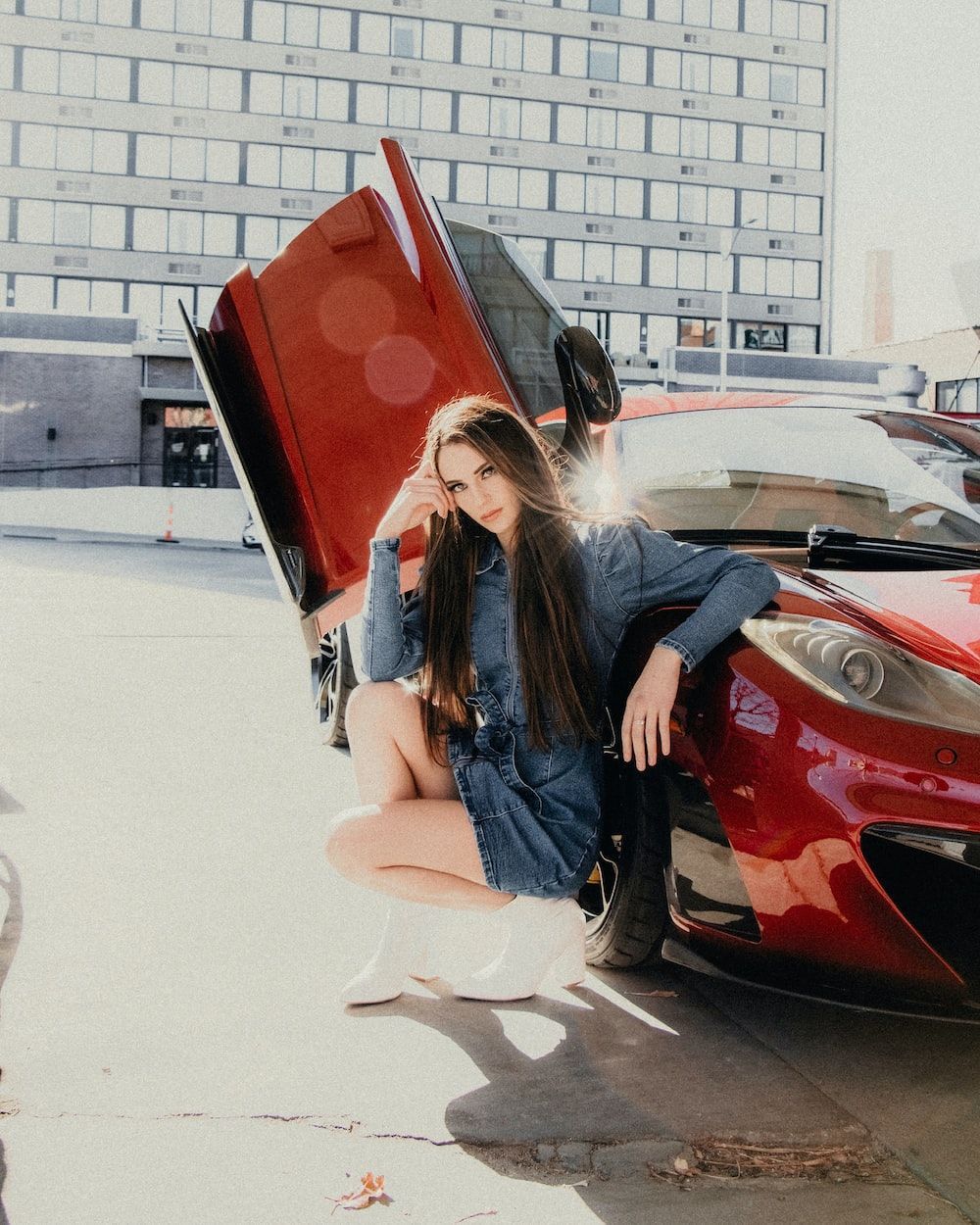 1000x1250 Woman in blue denim jacket and white pants sitting on red car photo