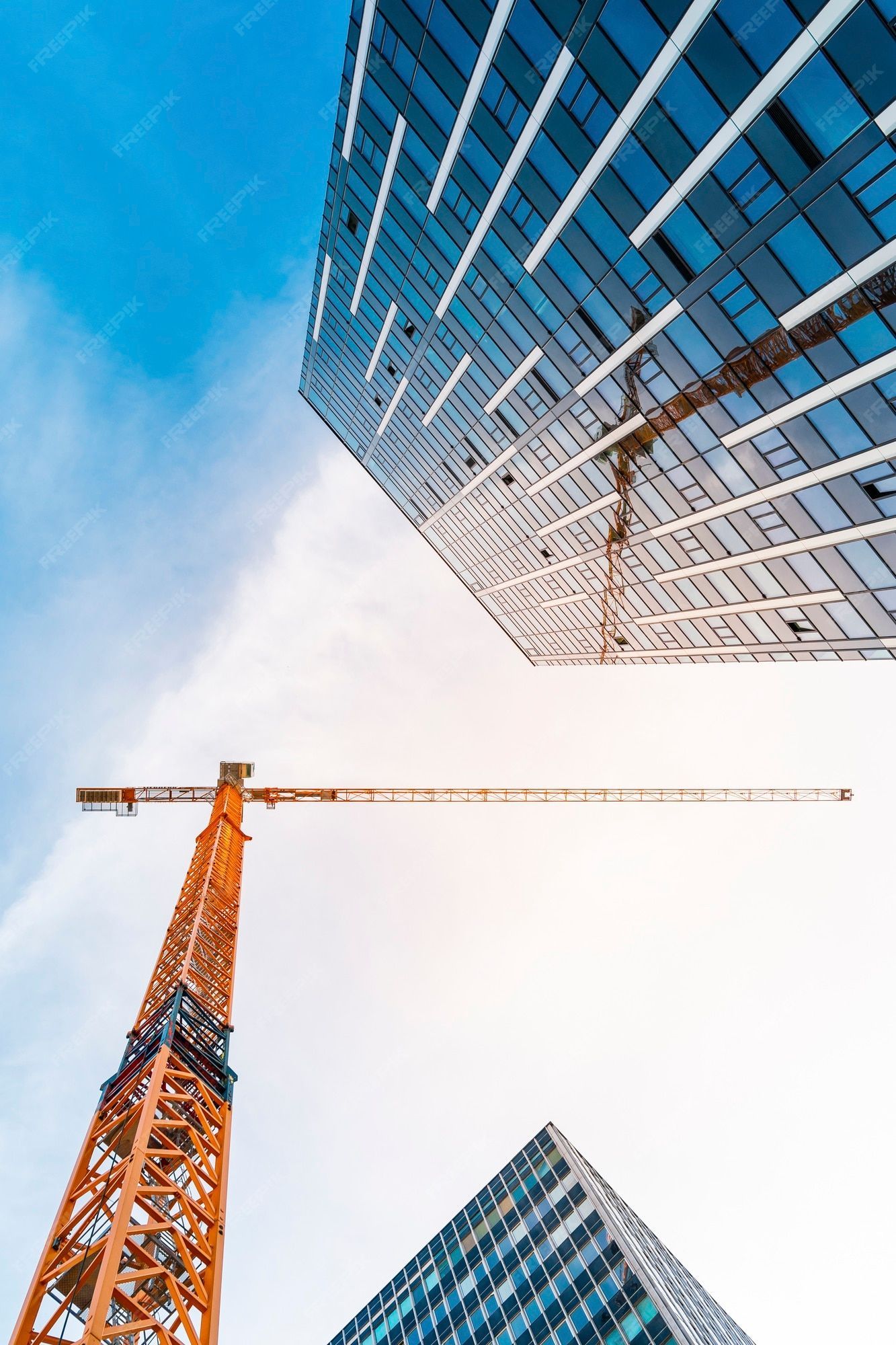 1333x2000 Premium Photo. Yellow tower crane. bottom view of a tall construction crane next to a modern building