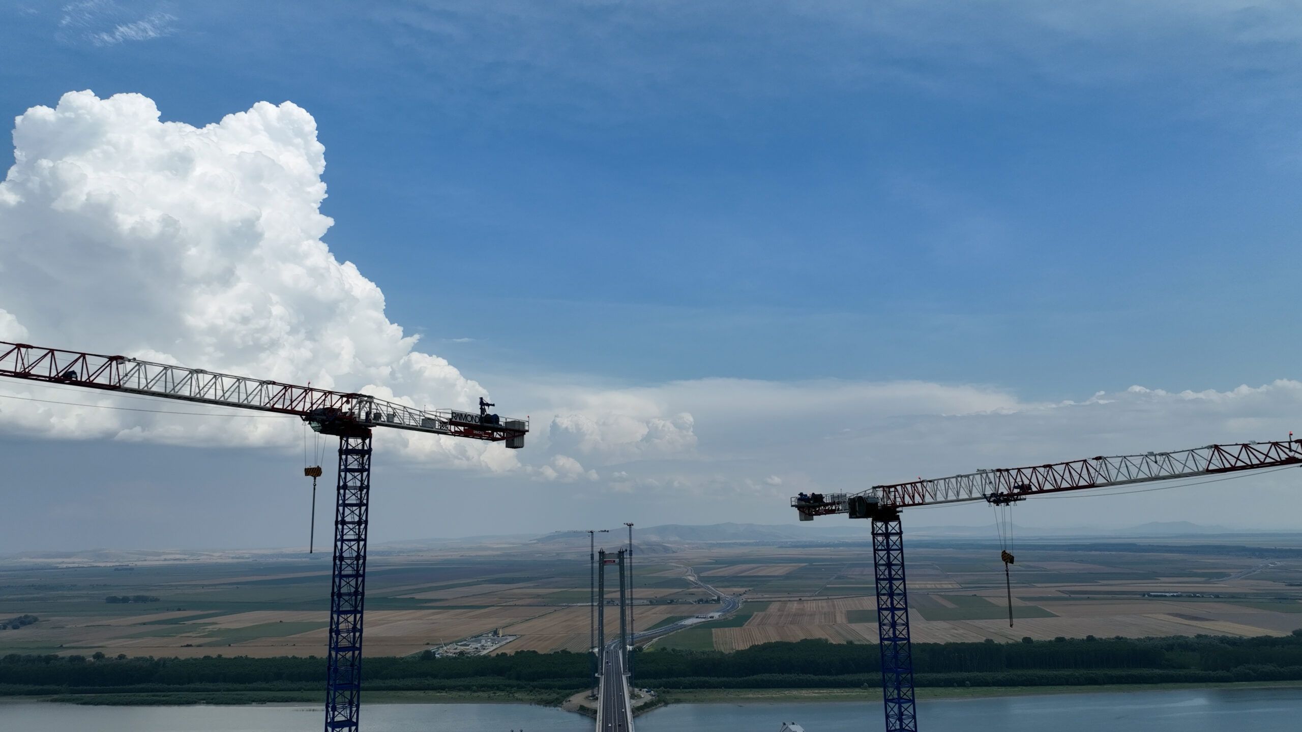 2560x1440 Raimondi MRT294 flat top tower cranes participate in the build of suspension bridge in Romania