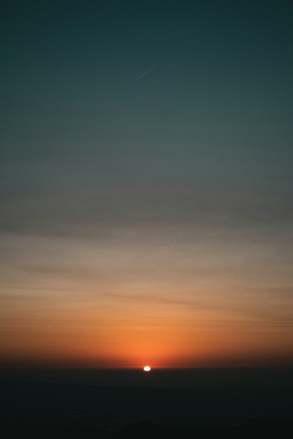 1000x1500 The sun is setting over the horizon of a city photo