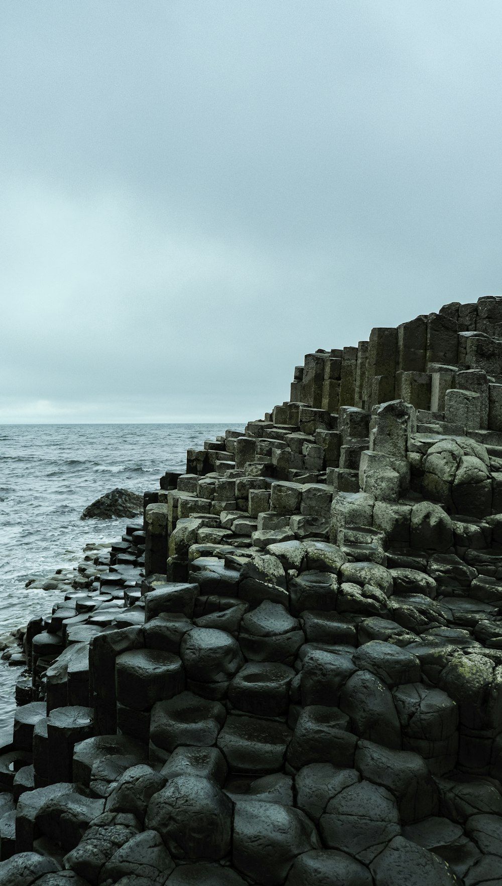 1000x1766 A large body of water next to a rocky shore photo