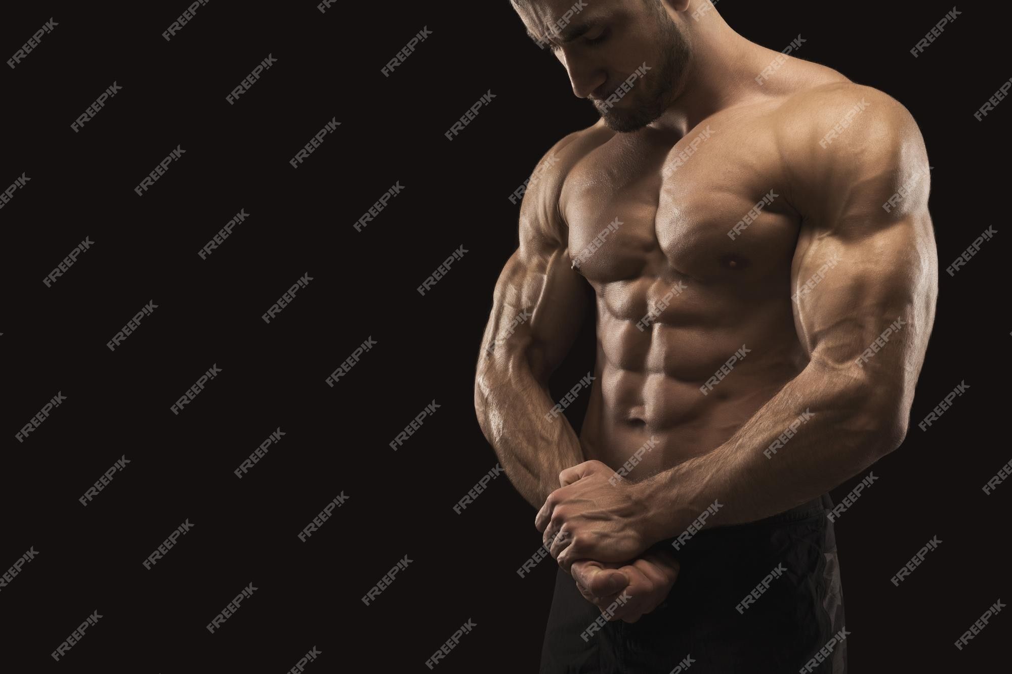 2000x1333 Premium Photo. Strong athletic man. handsome male fitness model showing big biceps and naked torso, muscular body. studio shot on black background, bodybuilding concept
