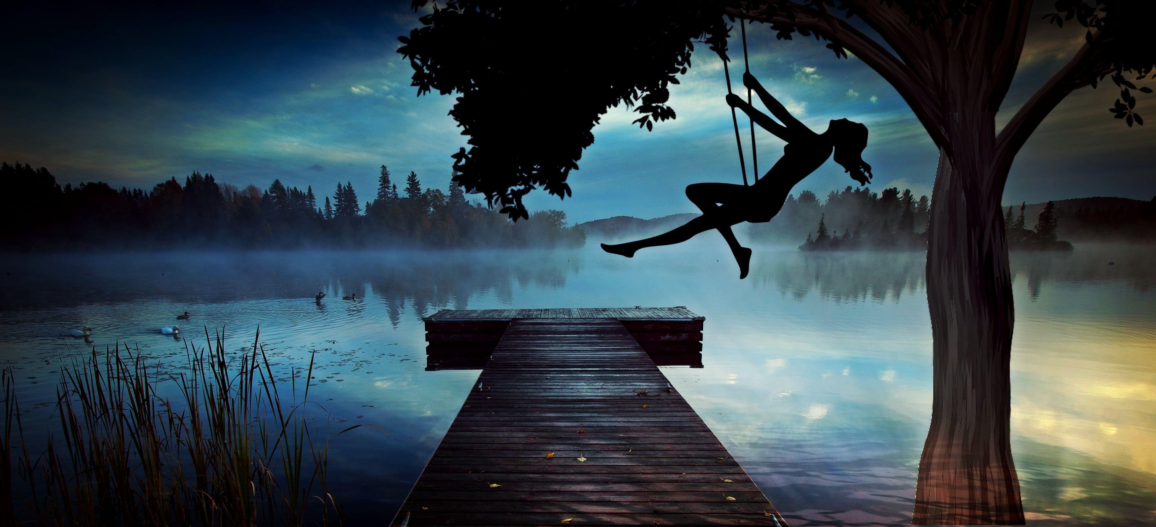 4000x1826 Silhouette of woman riding on swing near river dock and tree