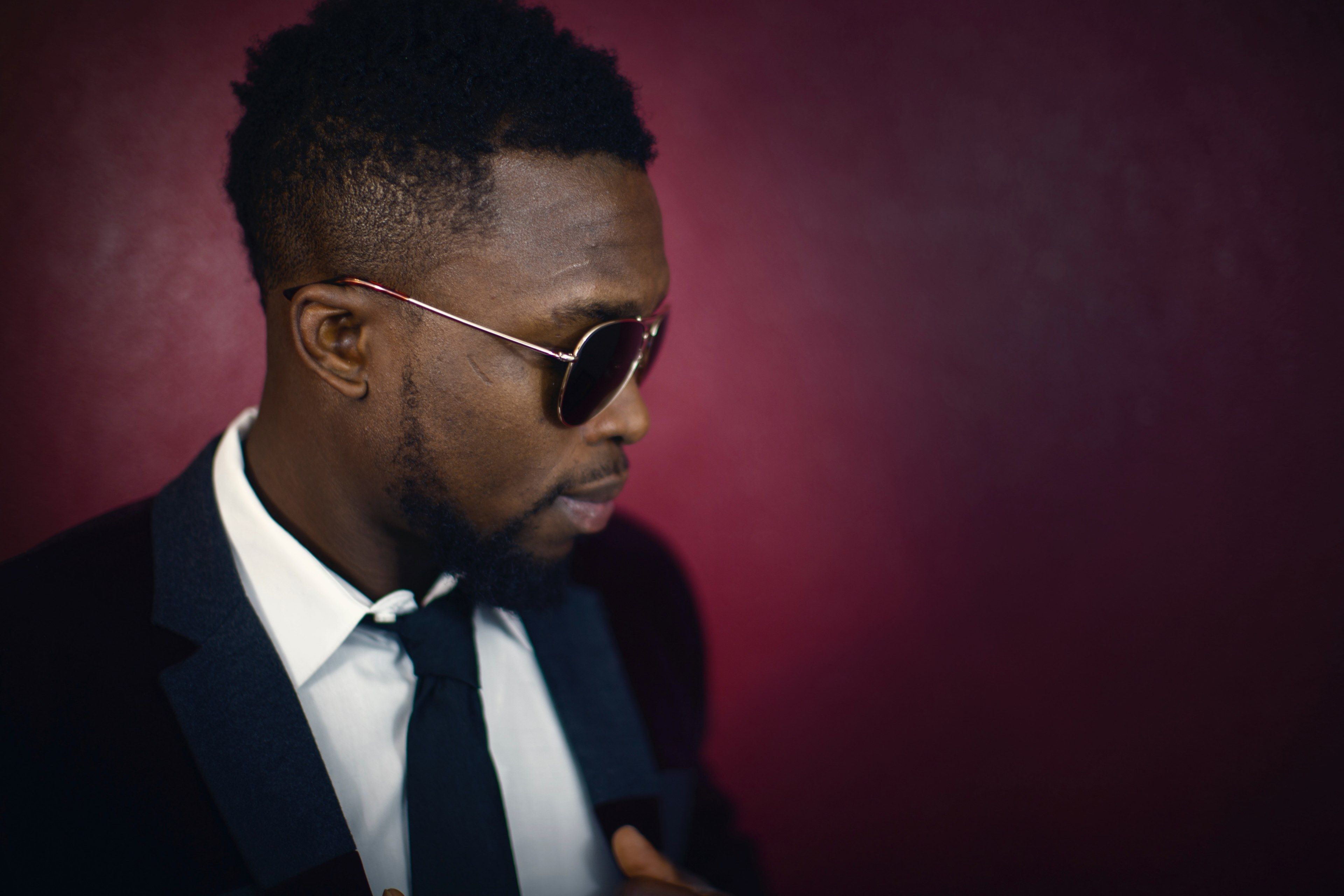 3840x2560 elegant man near a red wall 4k HD Wallpaper