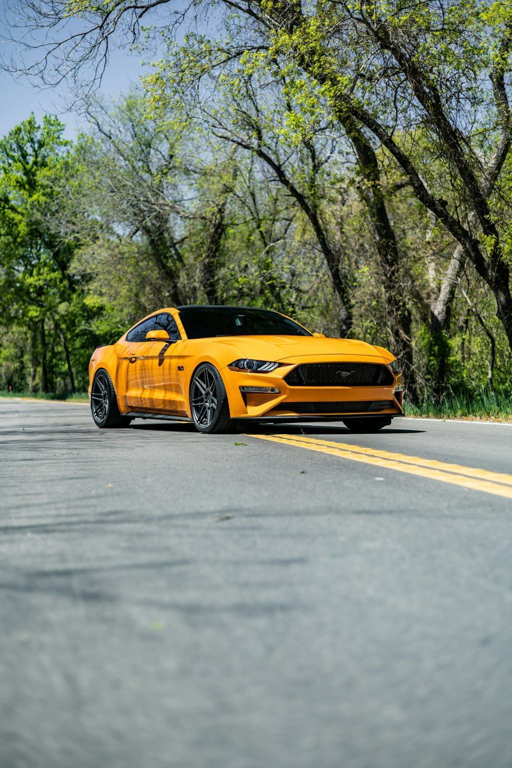 1000x1500 A yellow ford mustang parked on