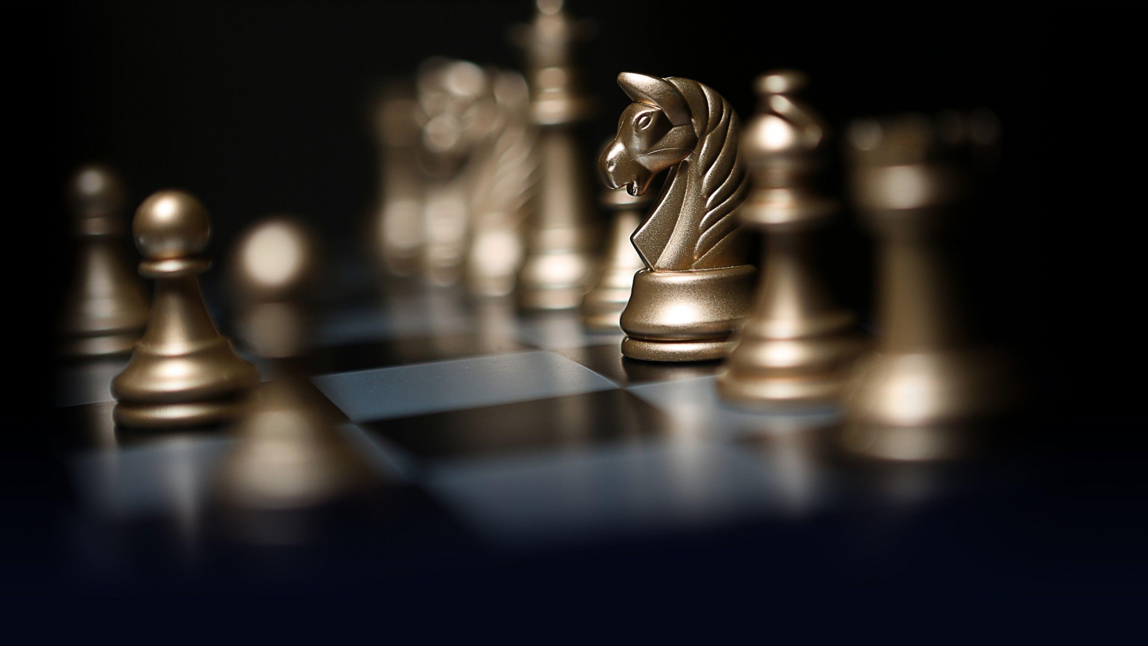 3840x2160 Gold chess pieces on a chessboard wallpaper and image