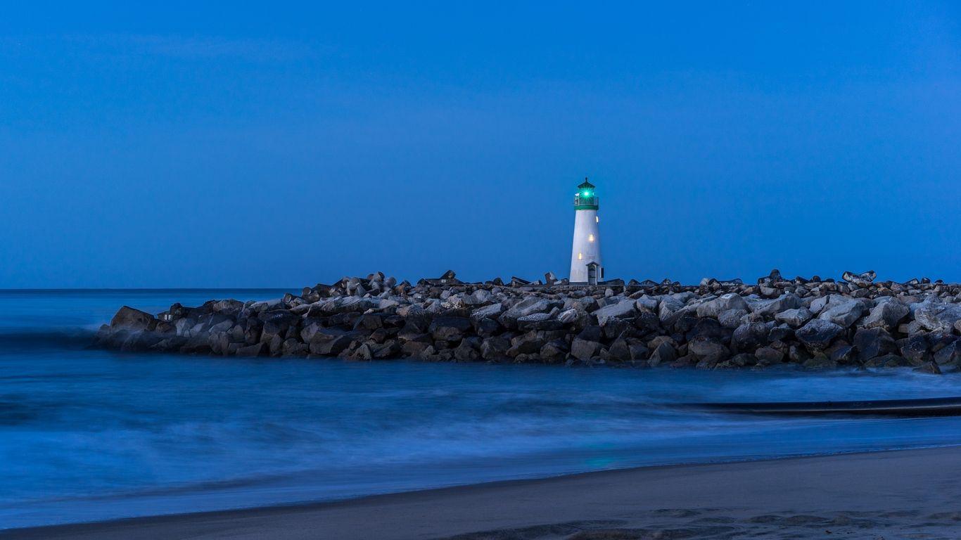 1366x768 Download wallpaper 1366x768 lighthouse, stones, sea, shore