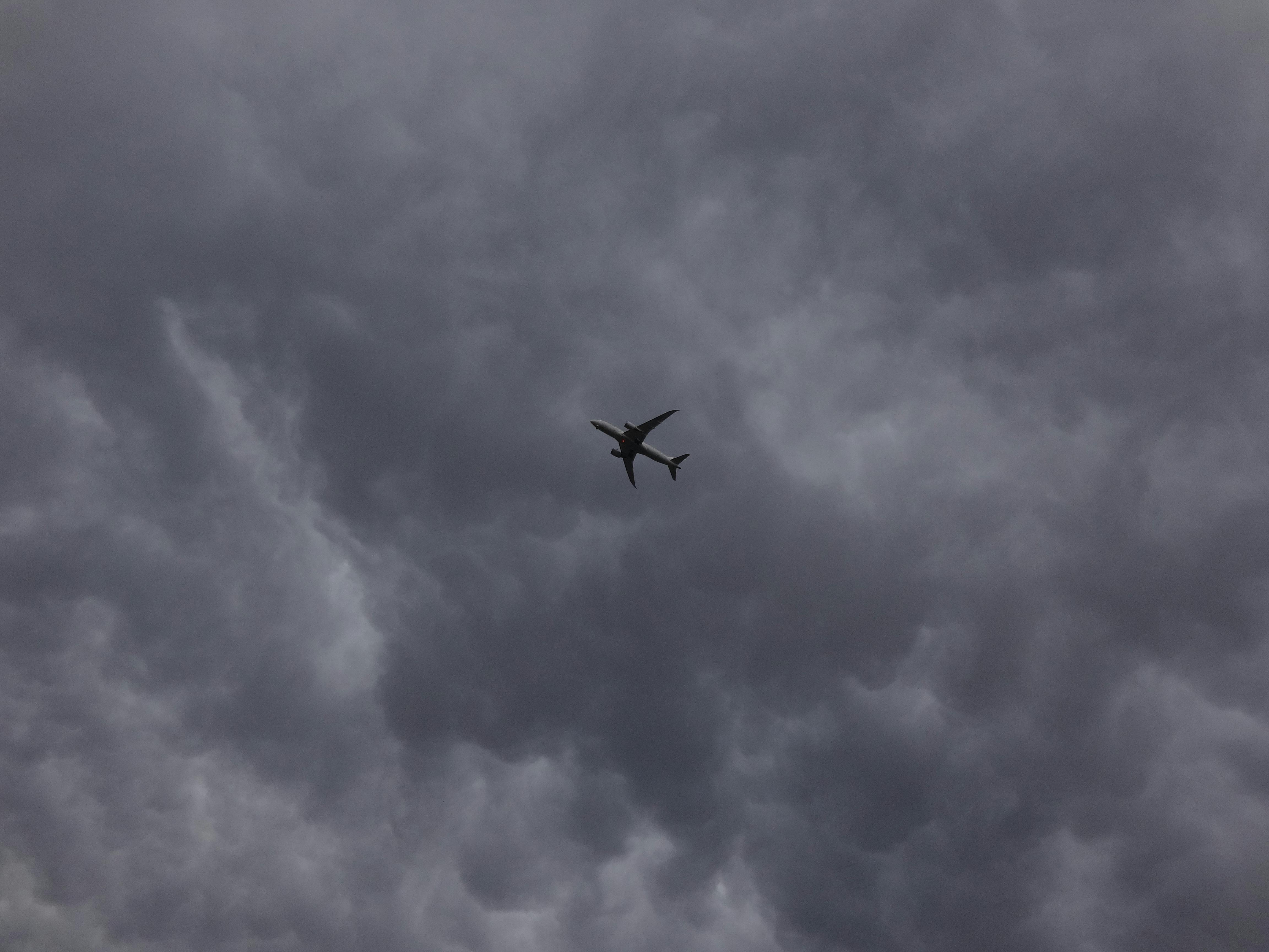 4608x3456 Airplane Flying Under the Dark Clouds