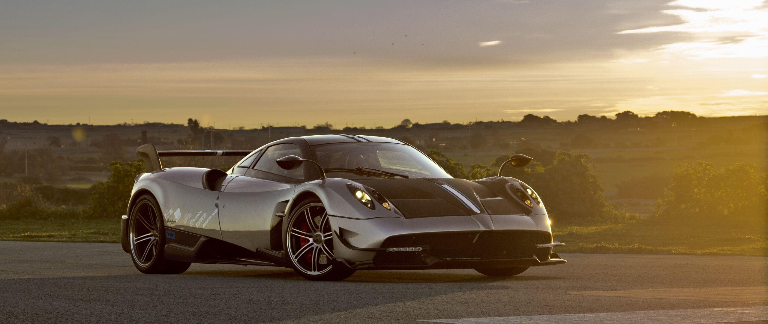 2560x1080 Download wallpaper 2560x1080 pagani, huayra, side view, road