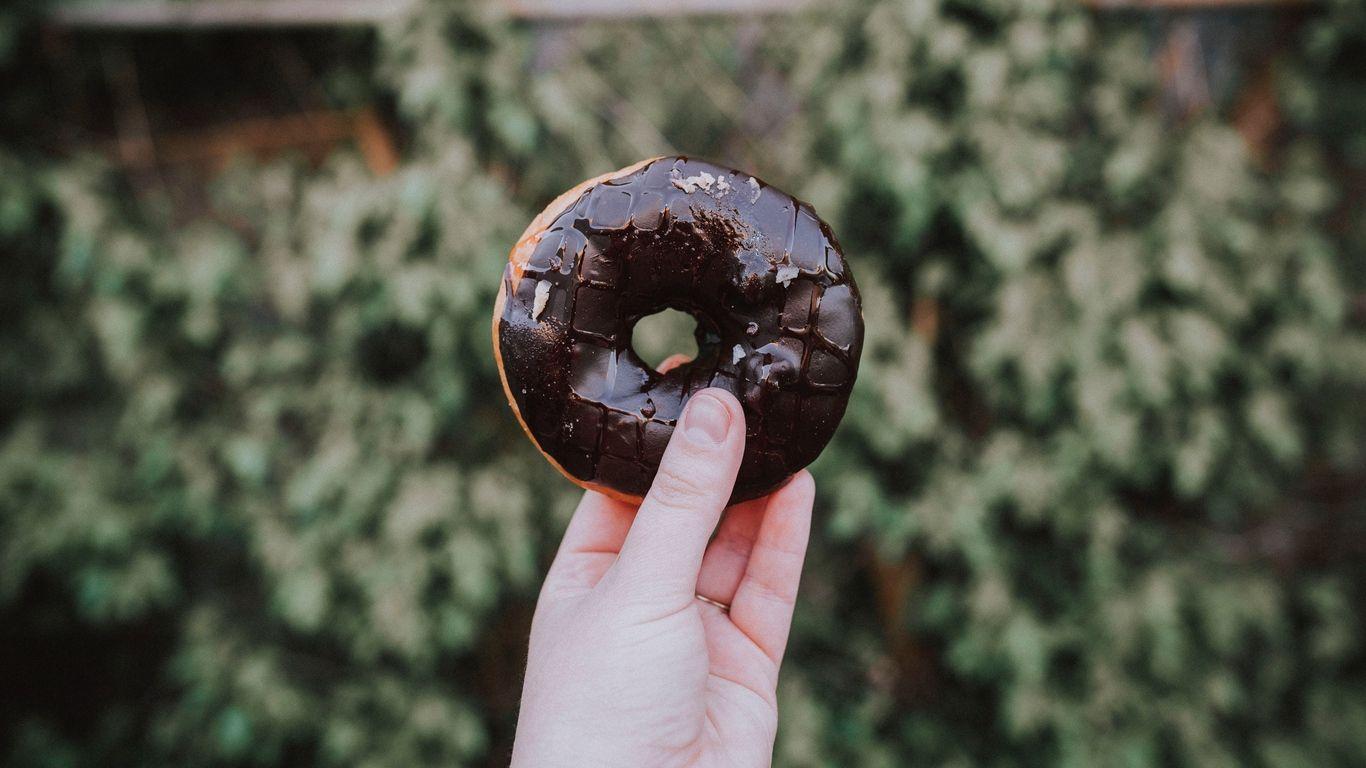 1366x768 Download wallpaper 1366x768 donut, hand, chocolate tablet