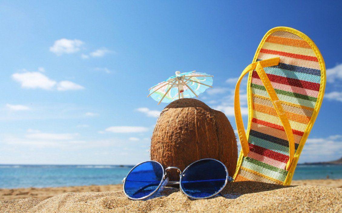 1130x706 Coconut, glasses and beach slipper in the sand