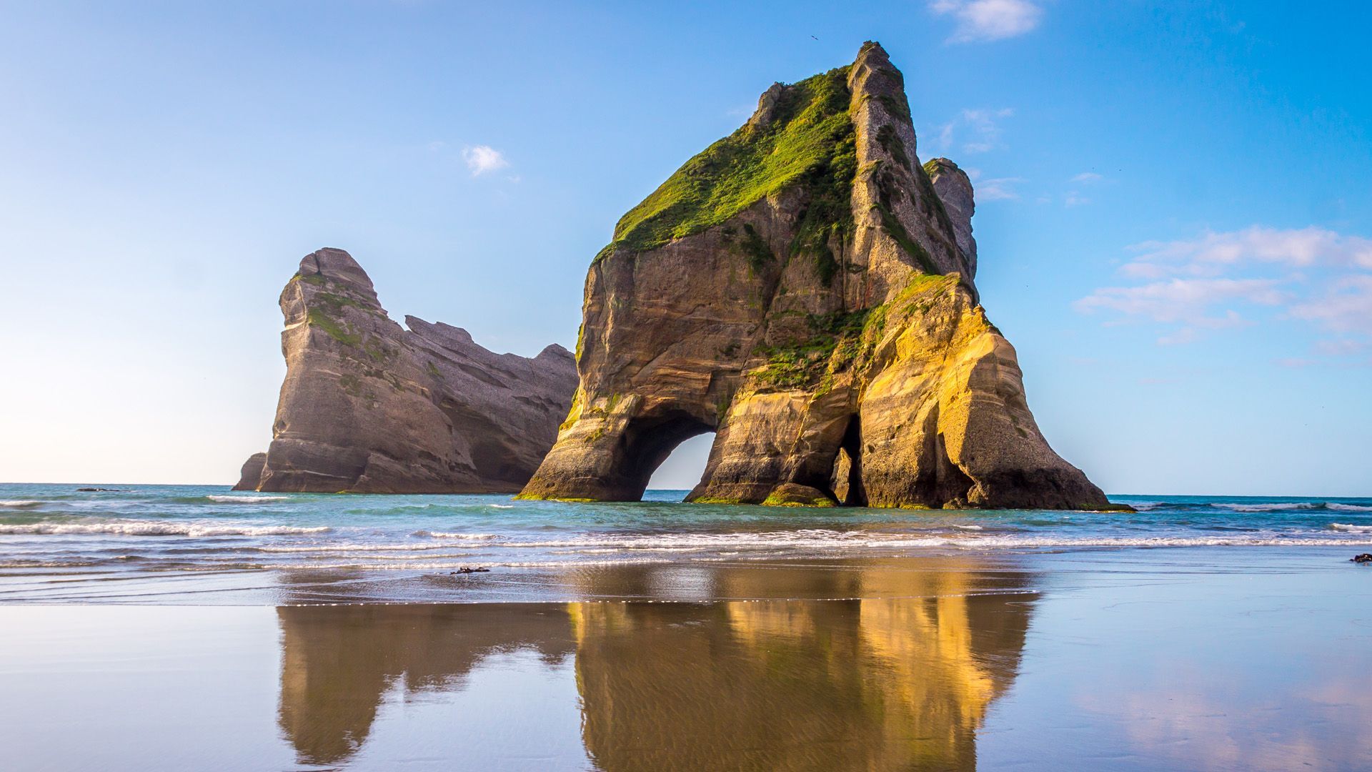 1920x1080 Rock Formations reflect in the water, Wharariki Beach, South Island of New Zealand. Windows Spotlight Image