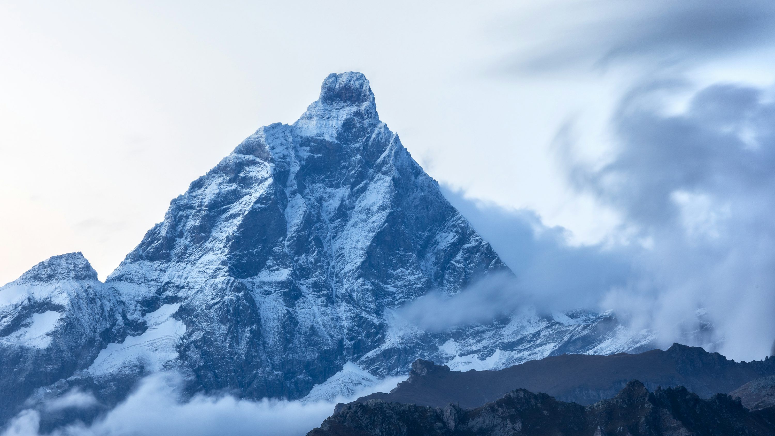 3000x1687 A mountain covered in snow and clouds