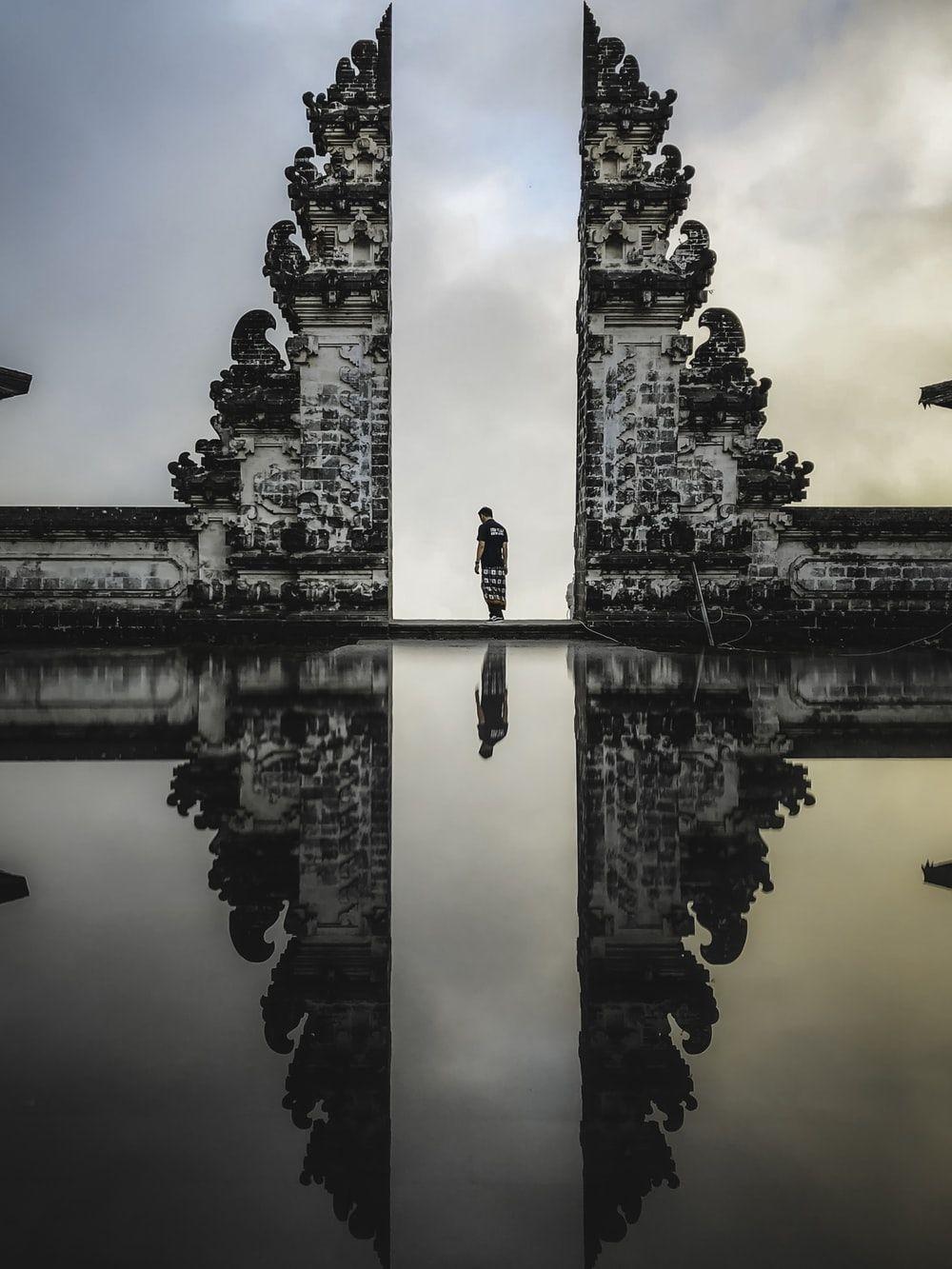 1000x1333 man standing between ruins in reflective photography photo