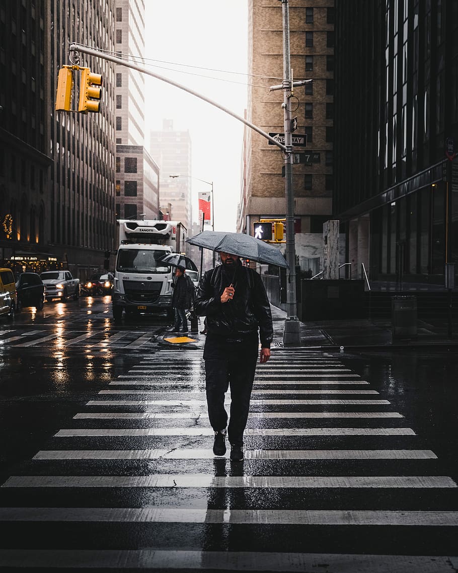 910x1138 HD wallpaper: man holding umbrella walking on pedestrian lane, person walking on pedestrian lane while holding umbrella