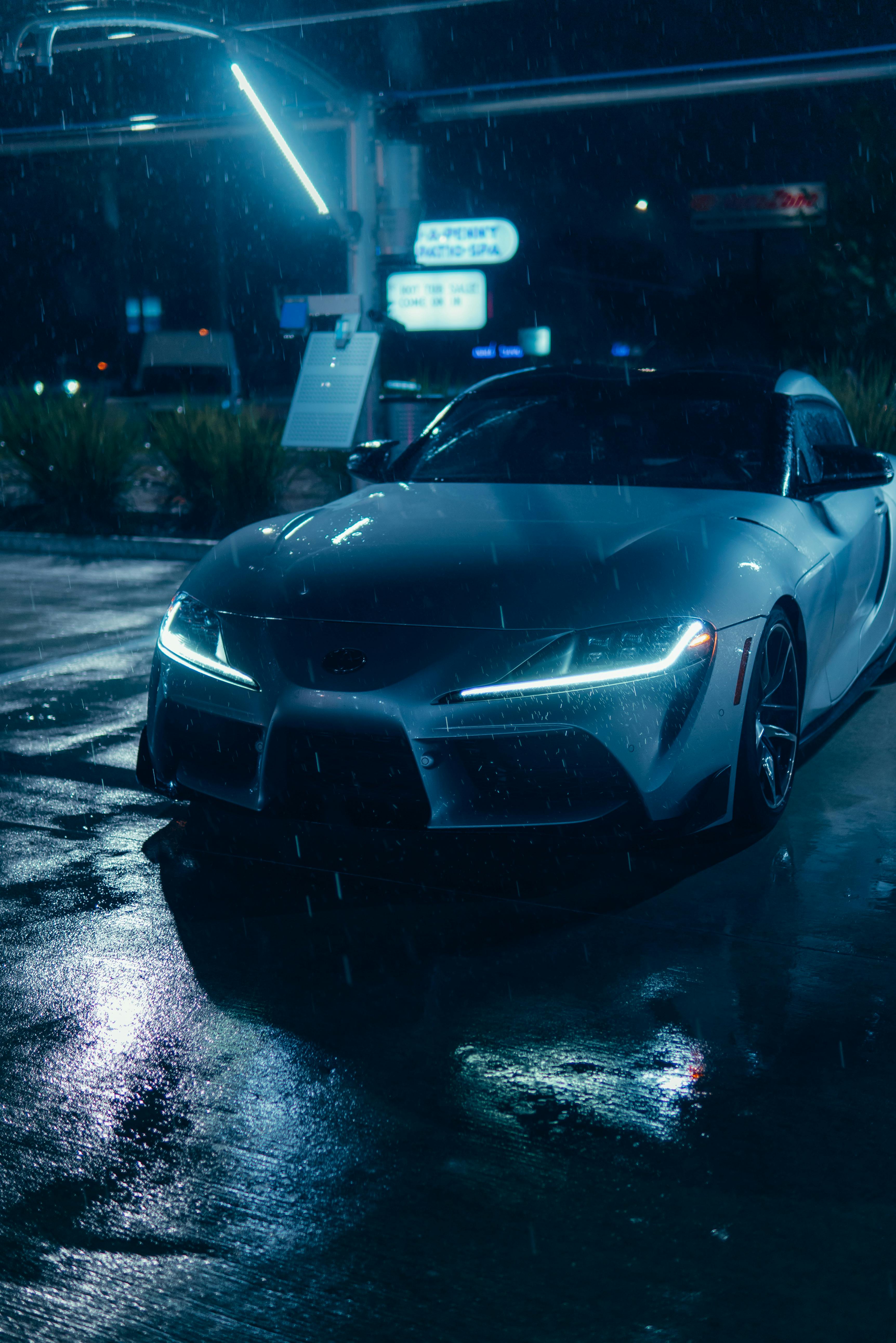 3448x5168 Sleek Car in Rain at Night Gas Station · Free