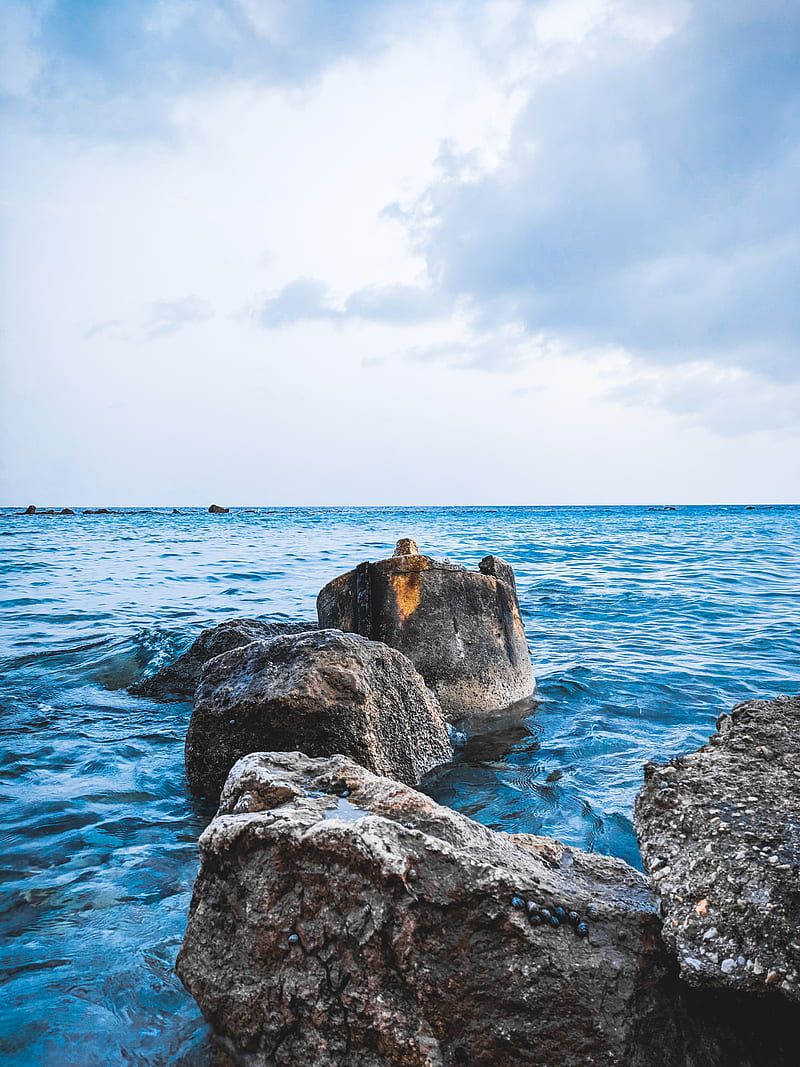 800x1067 Person standing on rock formation near sea during daytime, HD phone wallpaper