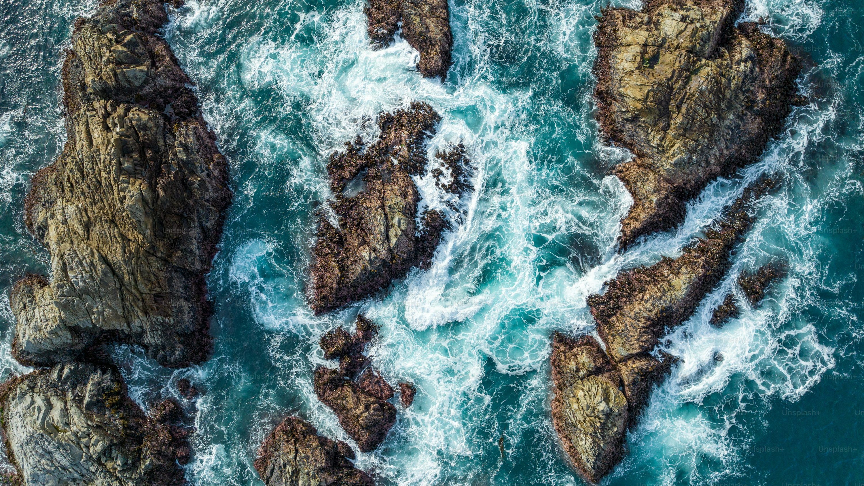 3000x1687 An aerial view of a rock formation in the ocean photo