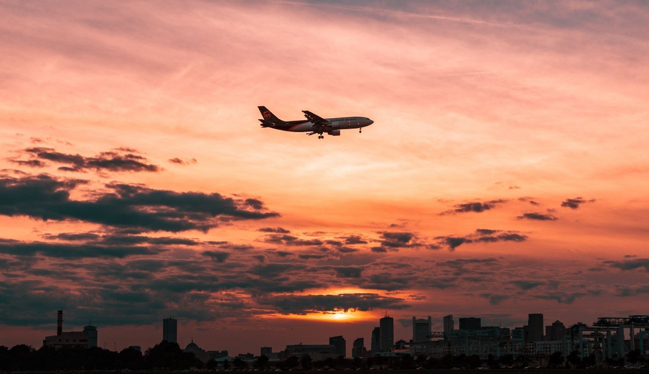 1299x750 Wallpaper White Airplane Flying Over The City During Sunset, Background Free Image