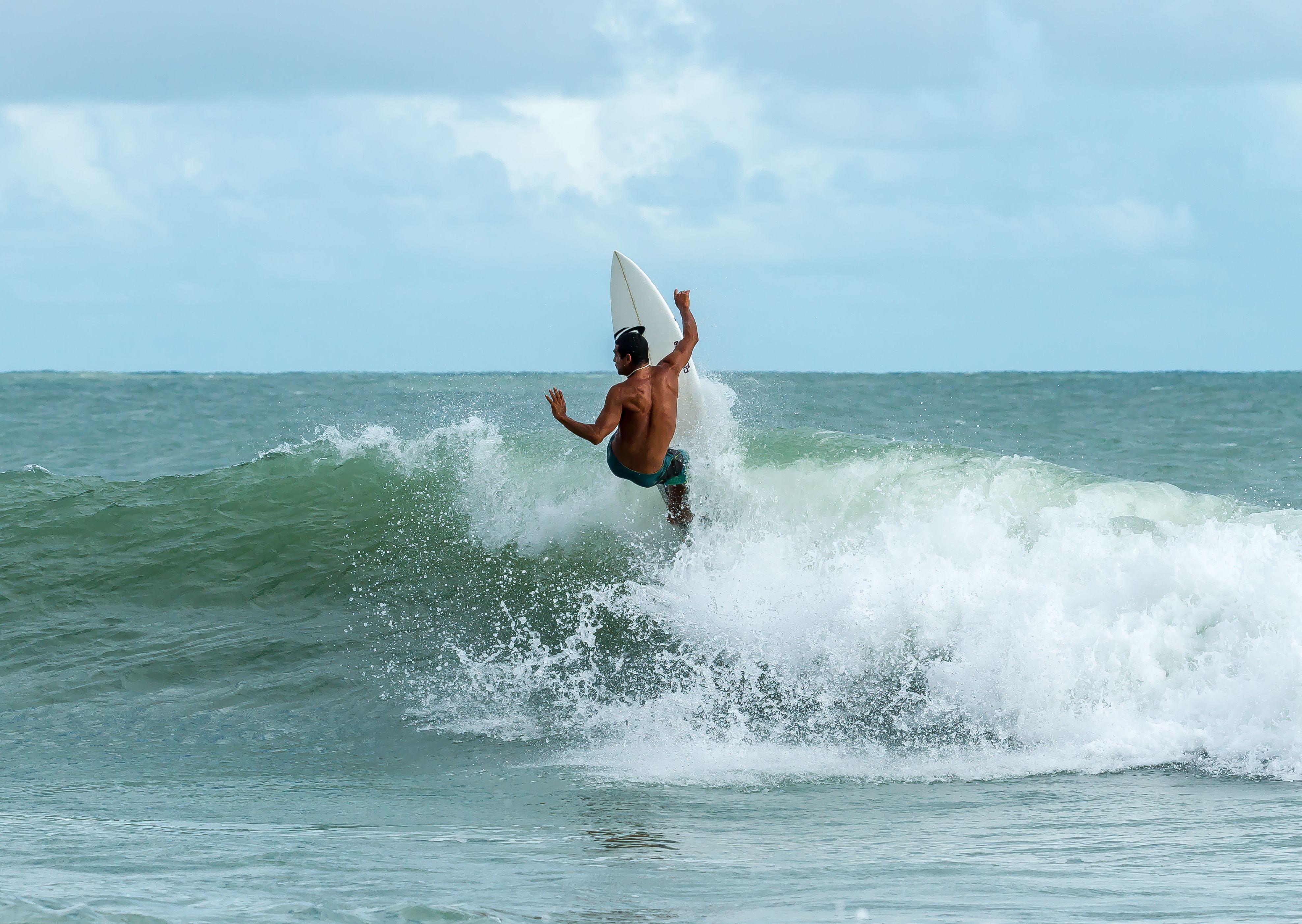 3953x2806 Man Riding Surfboard On Body Of Water wallpaper