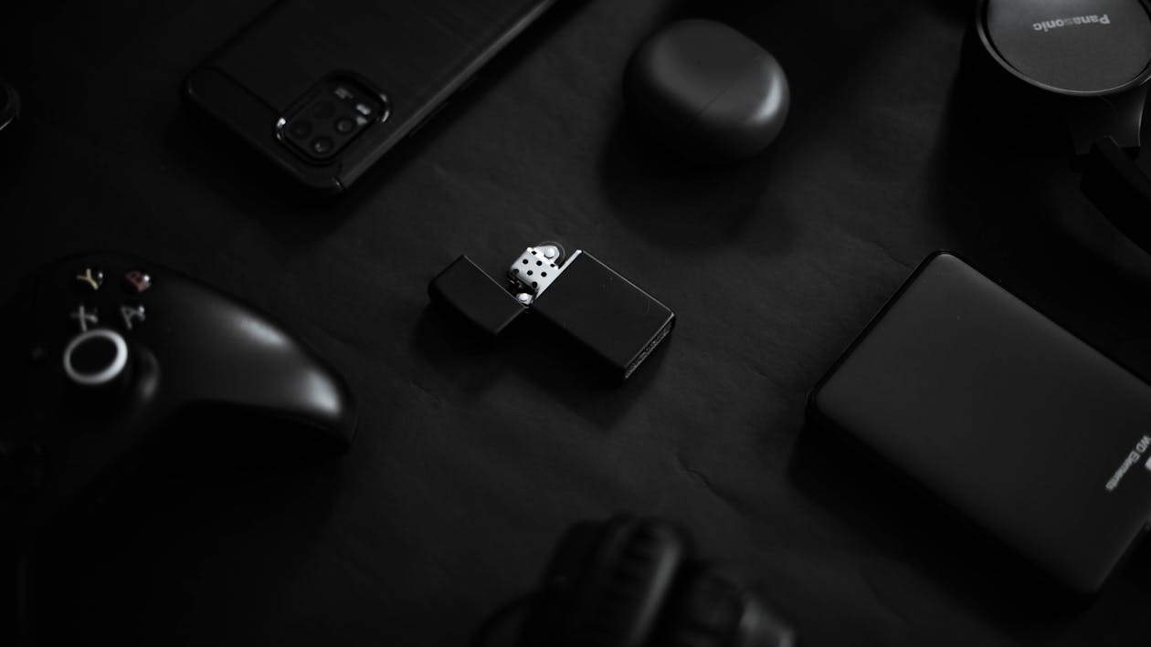 1260x709 A Lighter Surrounded by Black Things on a Black Surface · Free