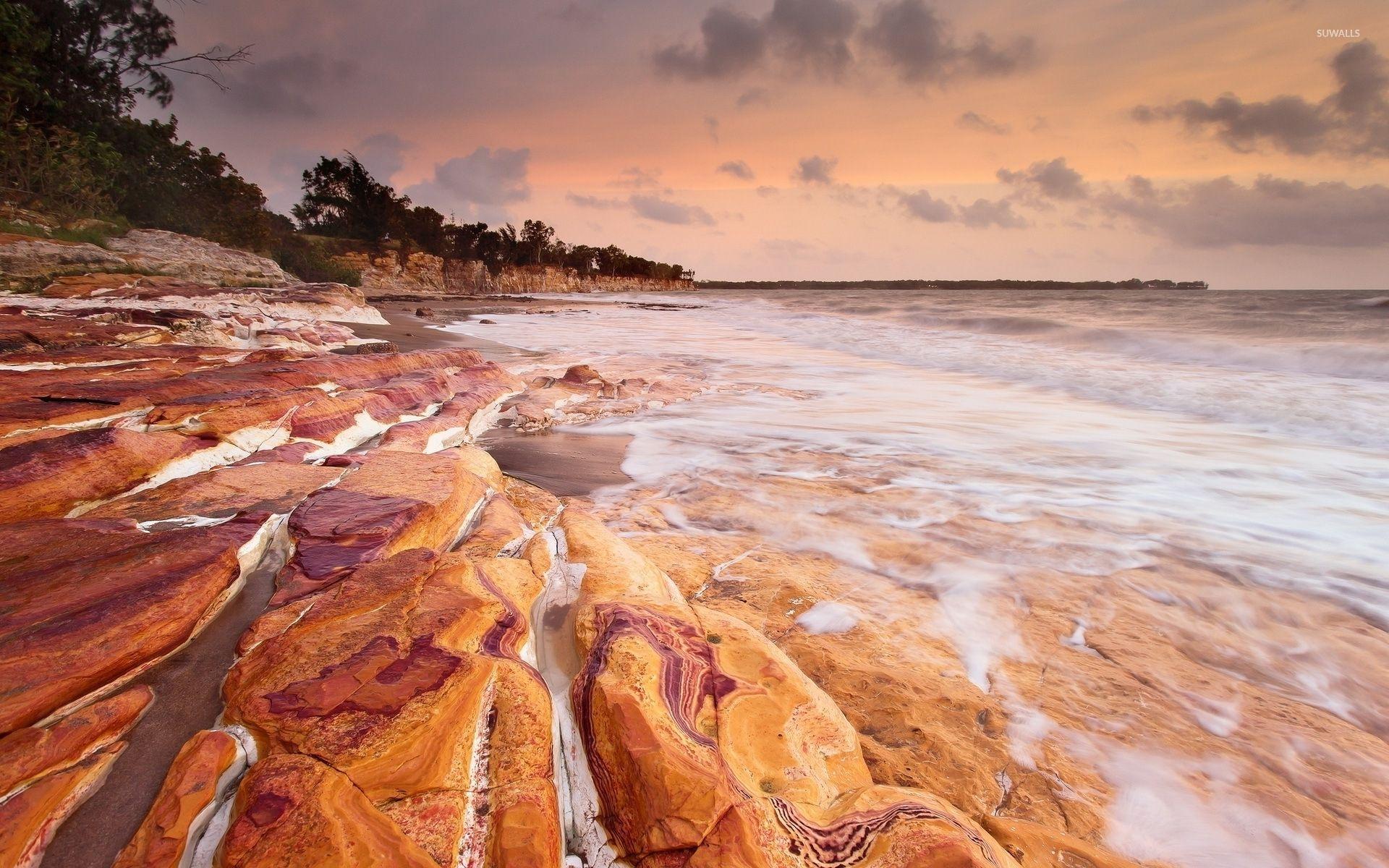 1920x1200 Rusty rocks washed by the foamy ocean waves wallpaper