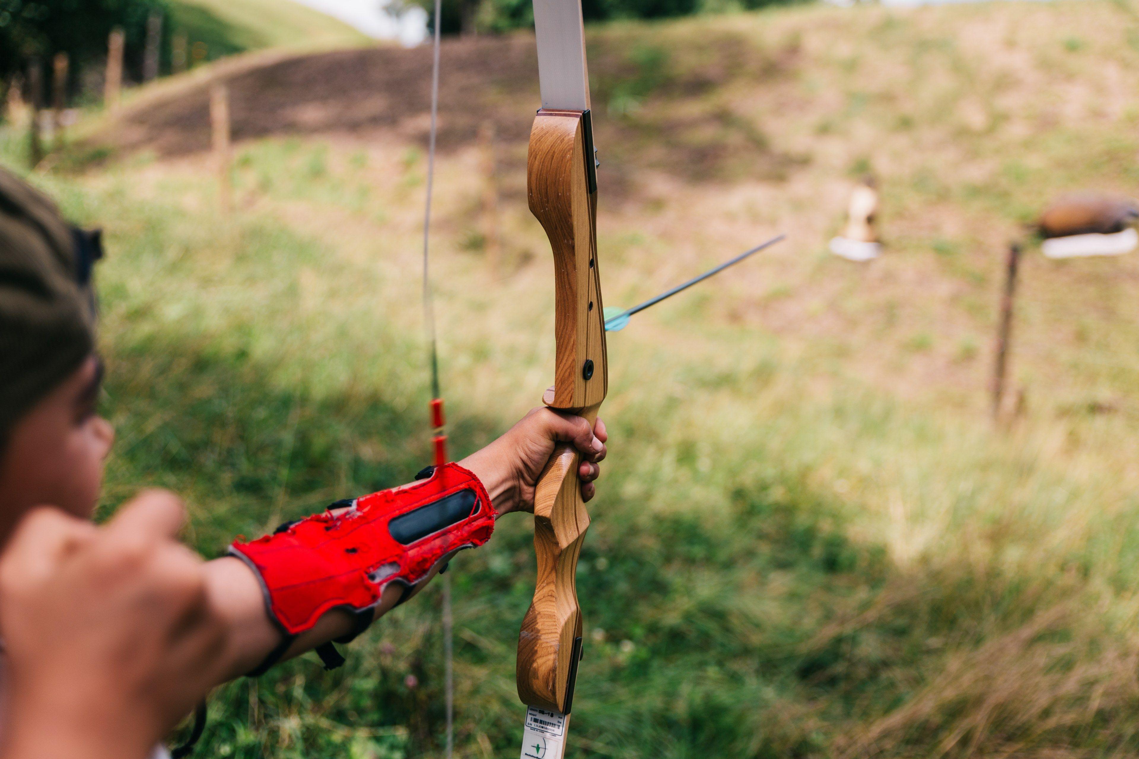 3840x2560 person holds bow and arrow and aims at targetfocus 4k wallpaper