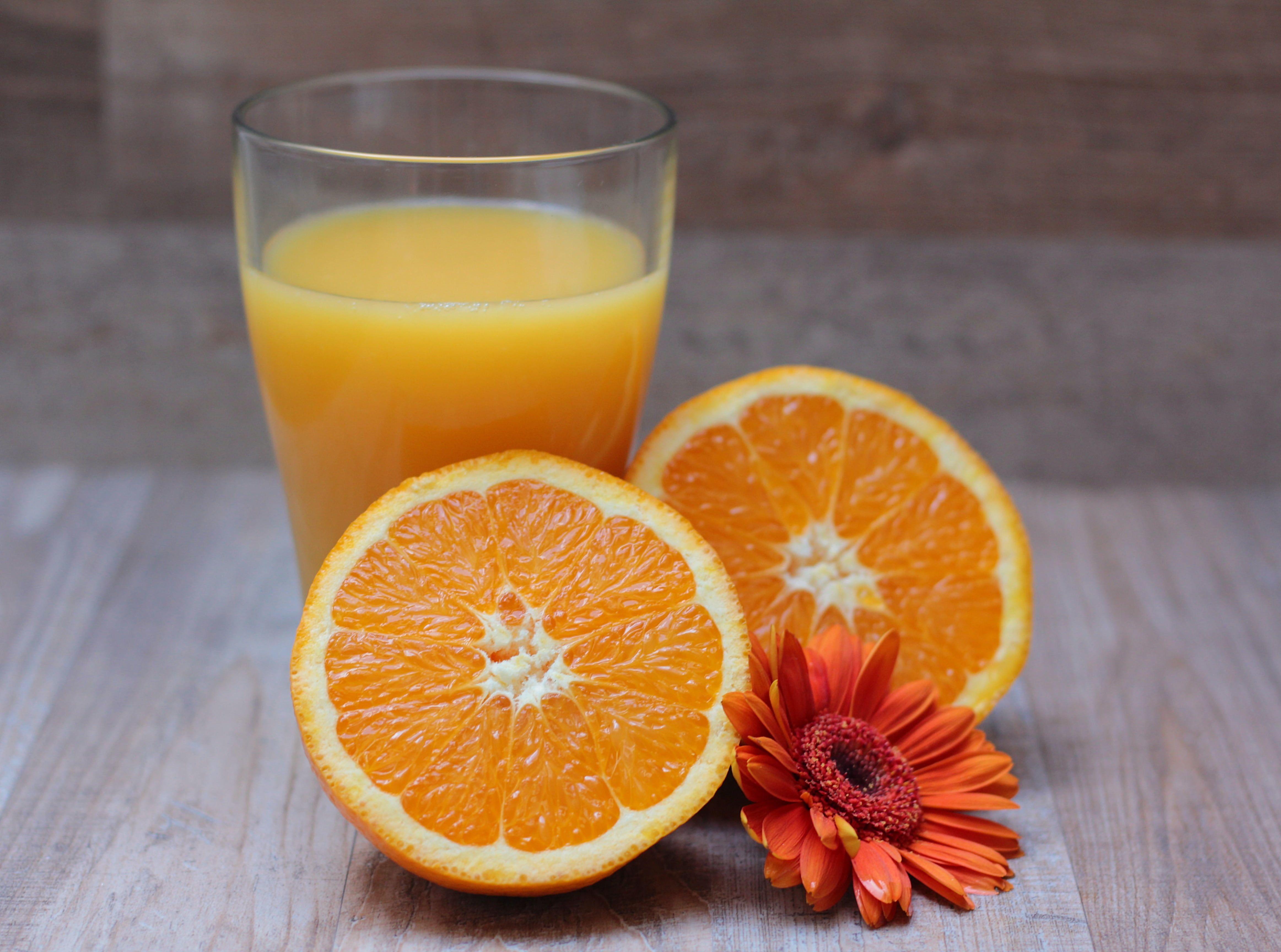 4649x3456 Two orange halves, orange gerbera daisy and glass of orange juice