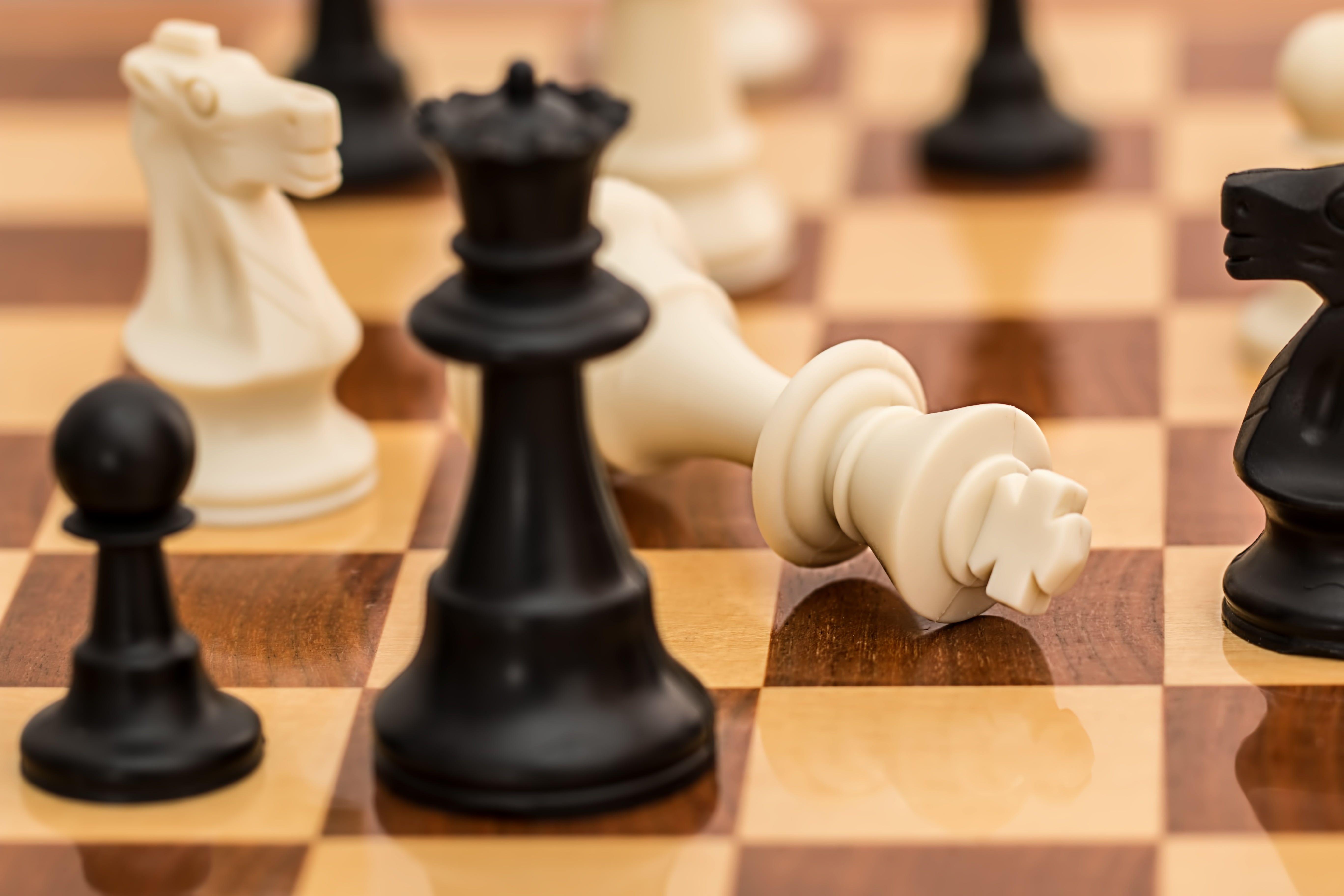 5472x3648 White King chess piece lying down beside black and white chess