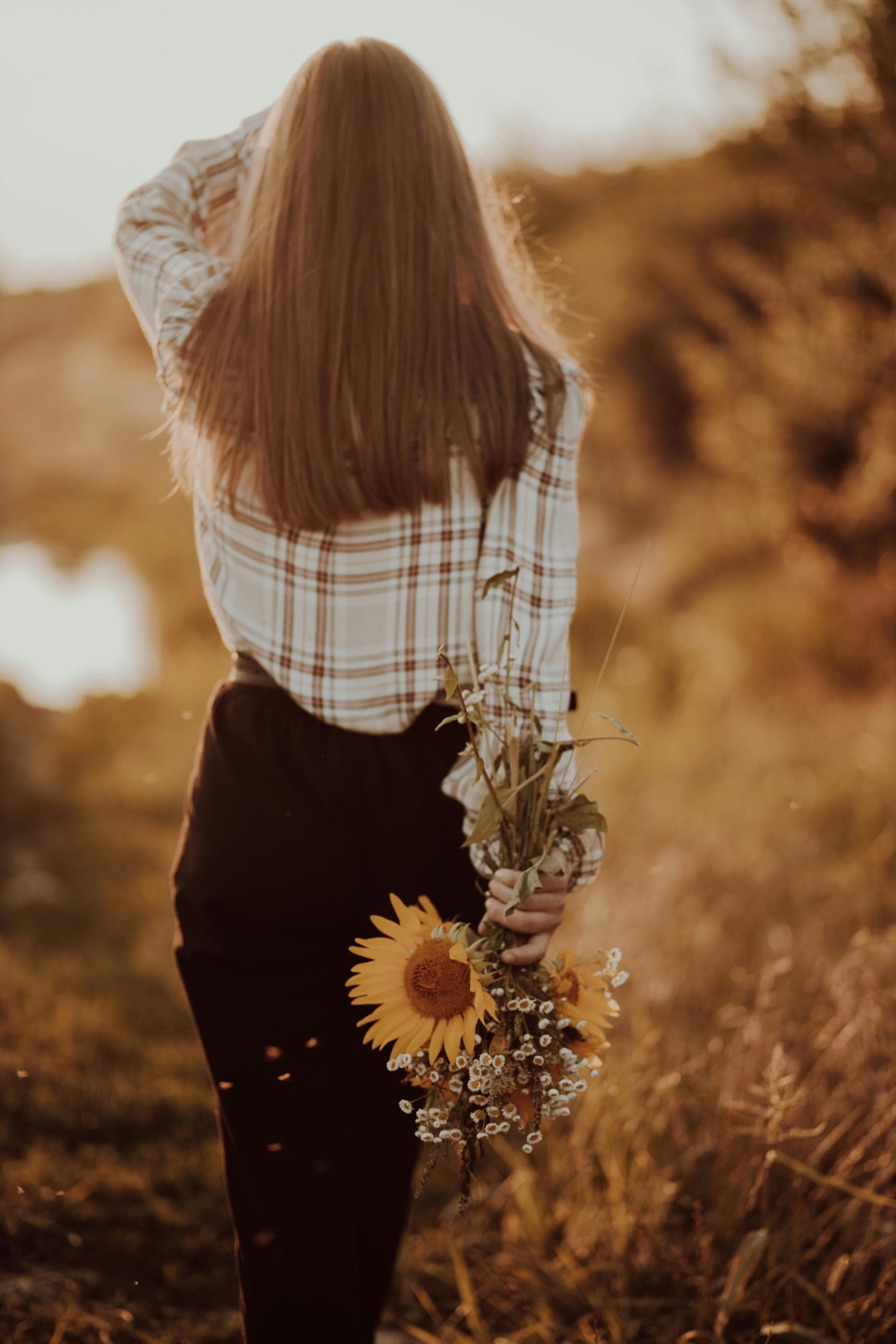 4480x6720 Back View of a Woman with Brown Hair Holding Flowers · Free