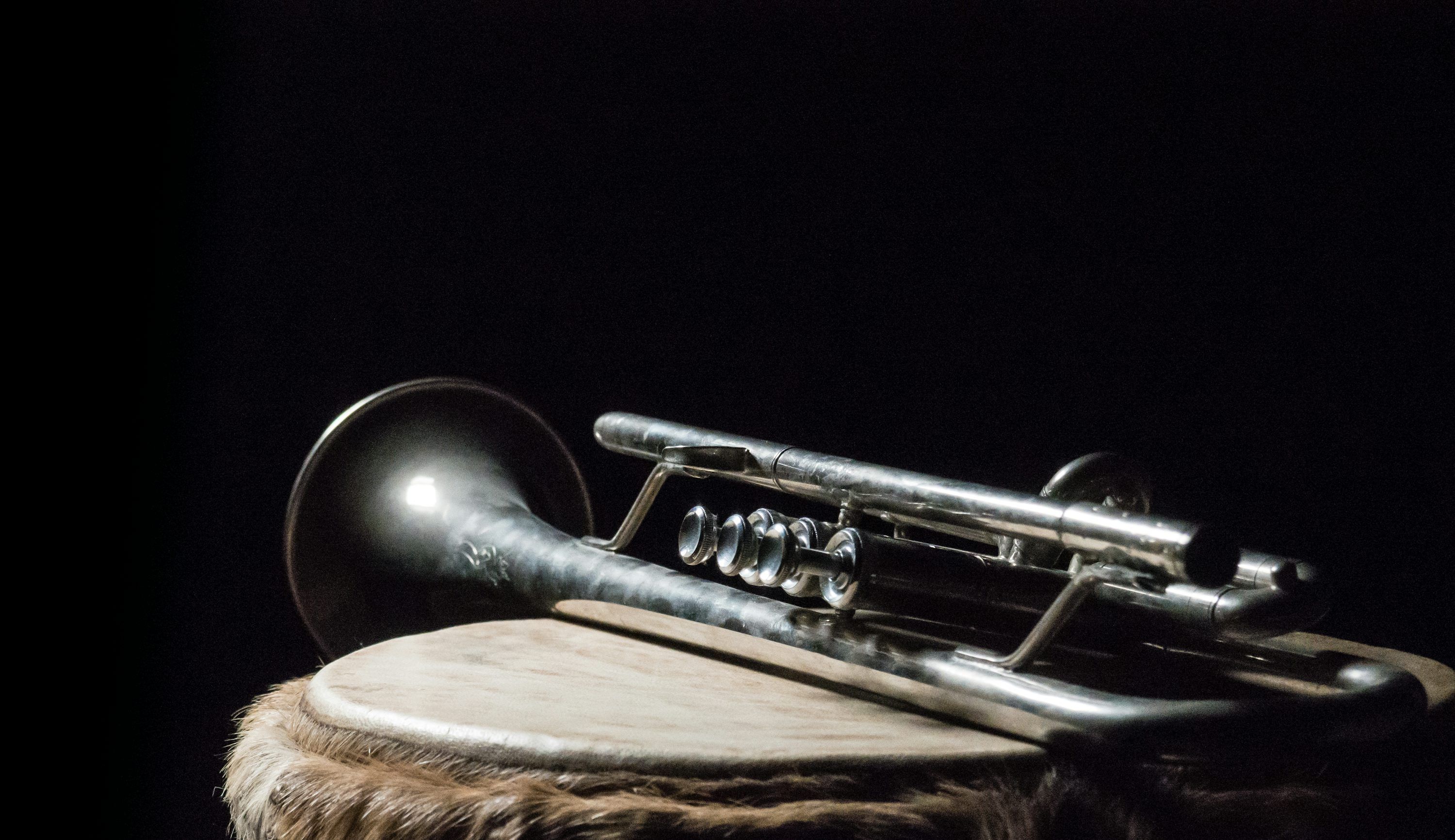 3000x1732 Silver trumpet on brown wooden surface photo