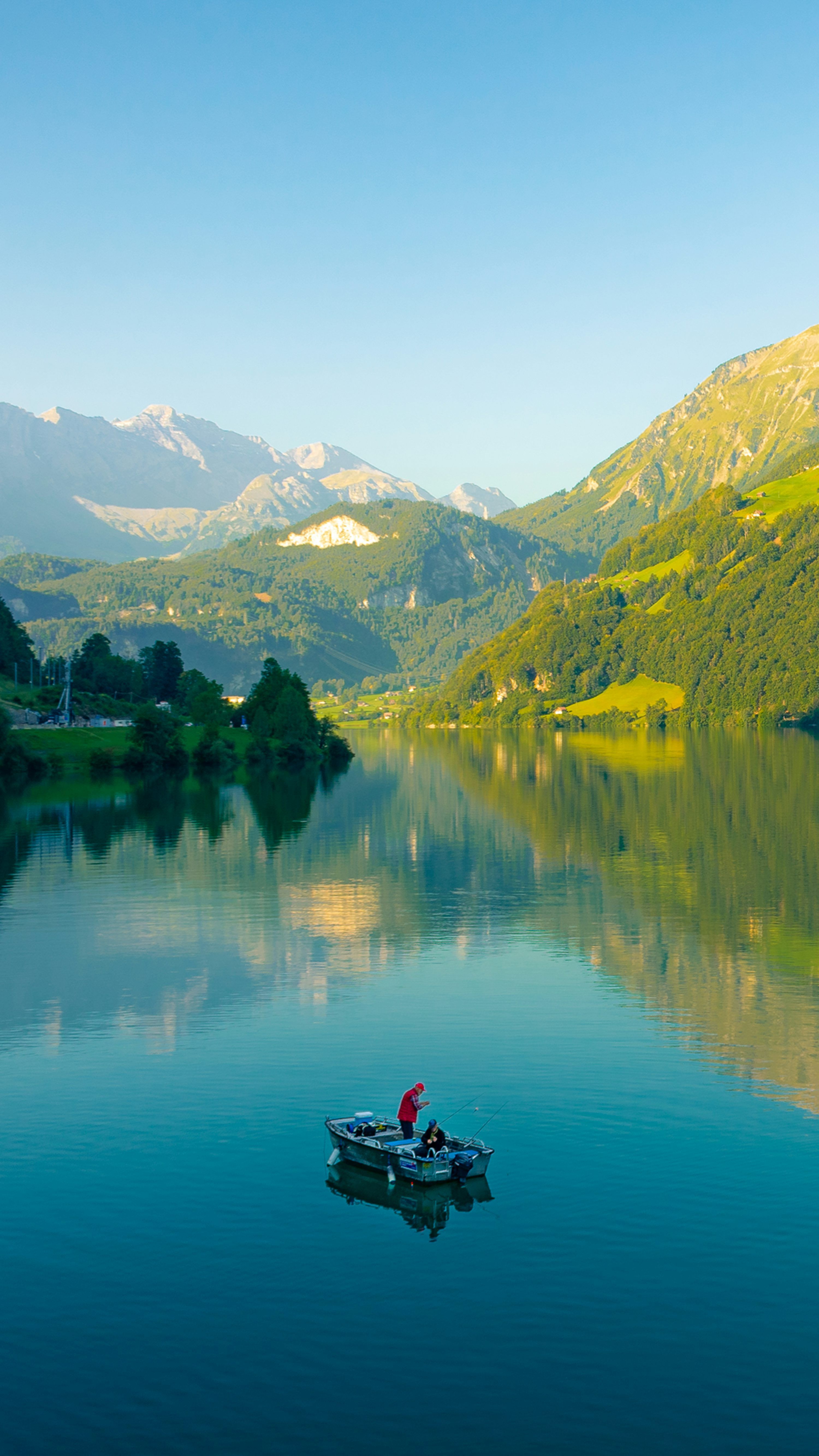 3000x5333 A small boat floating on top of a lake