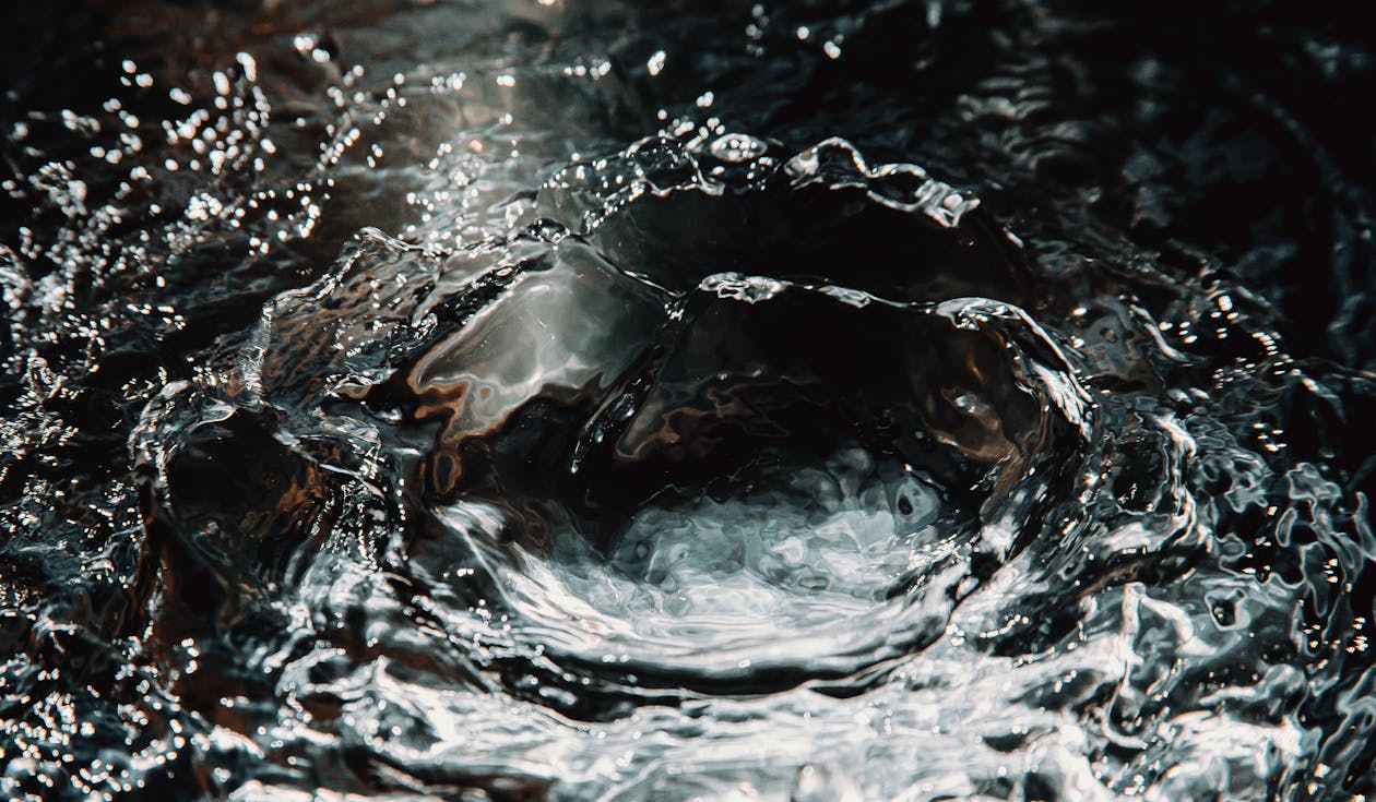 1260x735 Water splatter with drops glittering on black background · Free