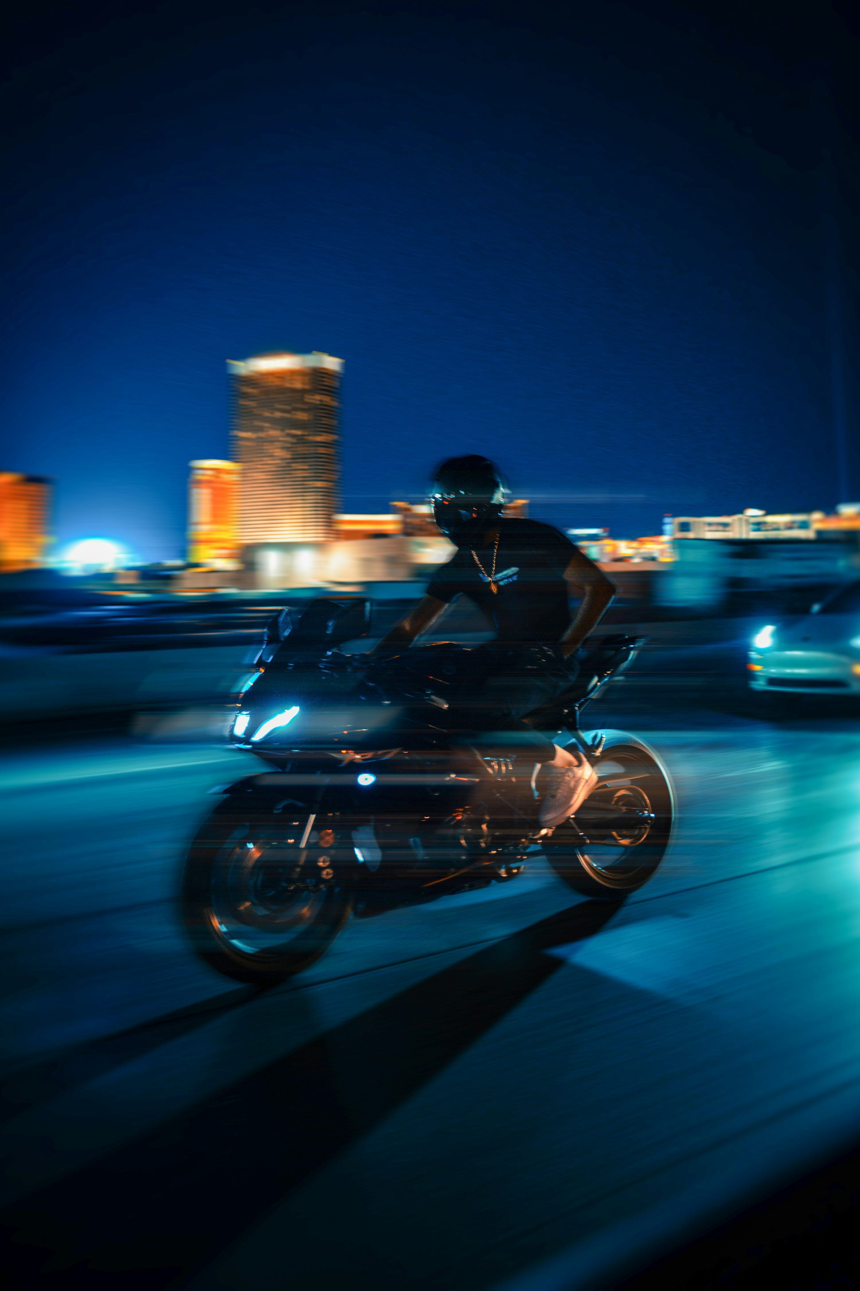 3000x4500 A man riding a motorcycle down a street