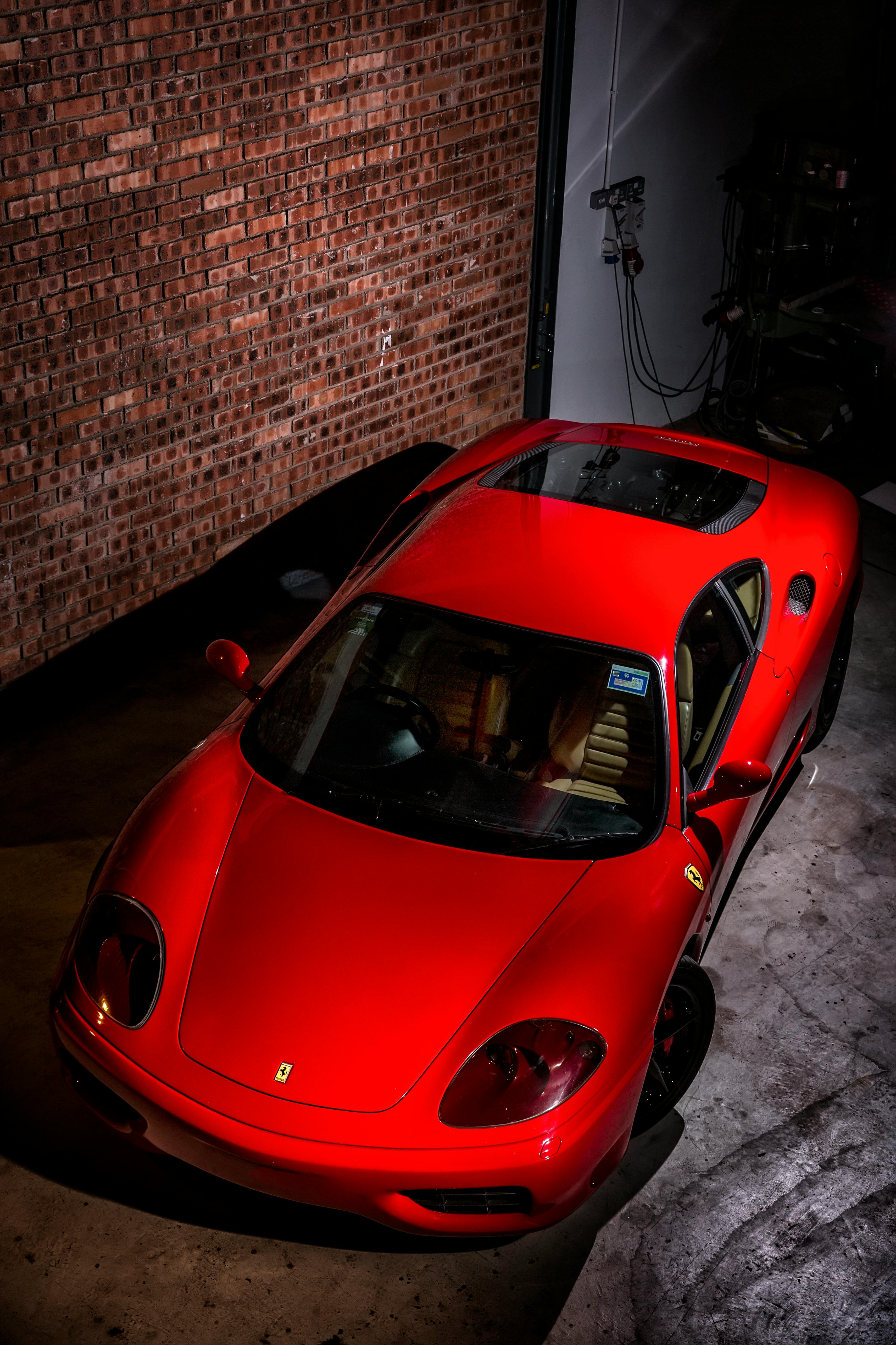 3423x5134 A Red Sports Car Parked inside the Garage · Free