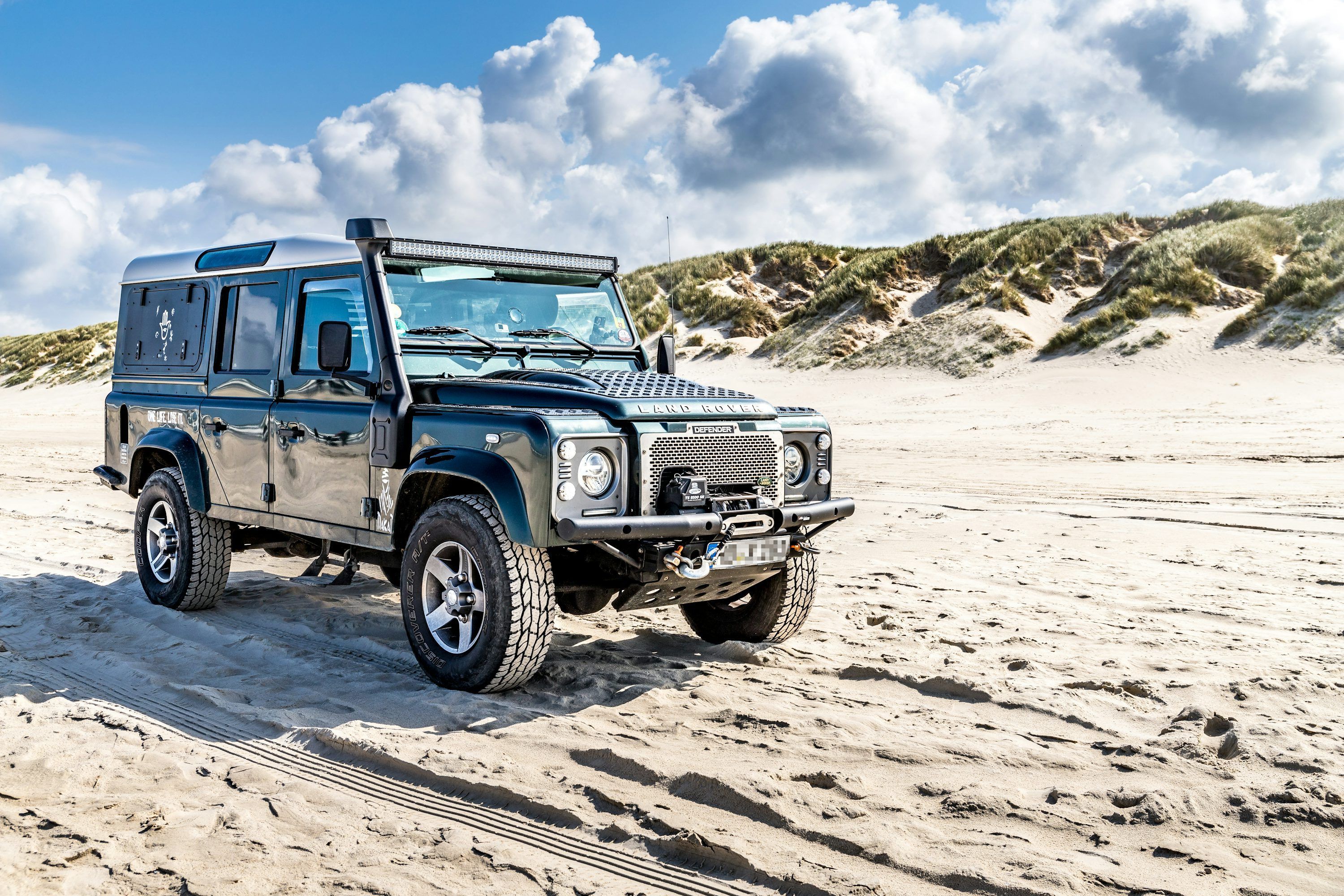 3000x2000 A black land rover on a sandy beach photo
