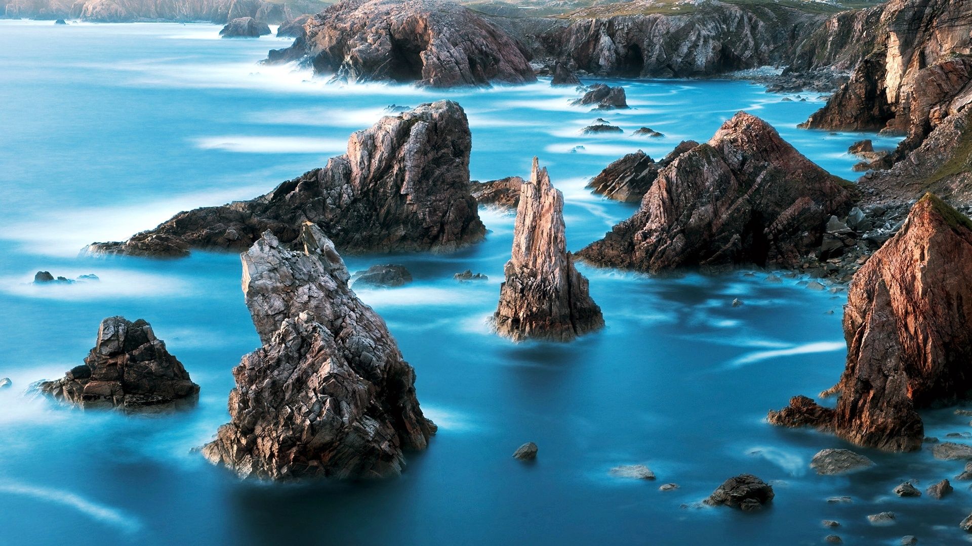 1920x1080 Majestic Ocean Blues: Nature's Rock Formations HD Wallpaper