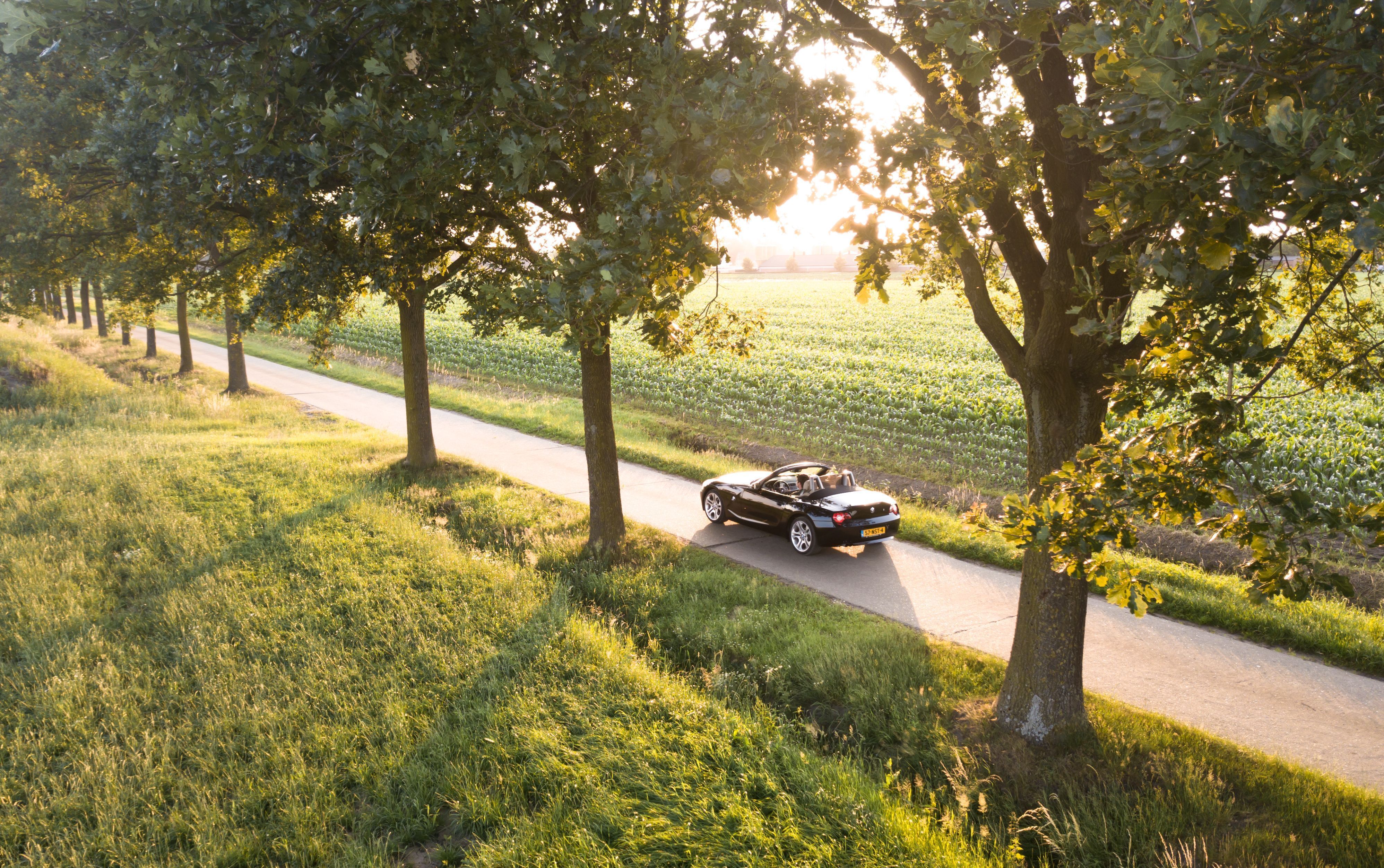 3992x2505 Download wallpaper 3992x2505 car, convertible, road, sunlight, nature HD background