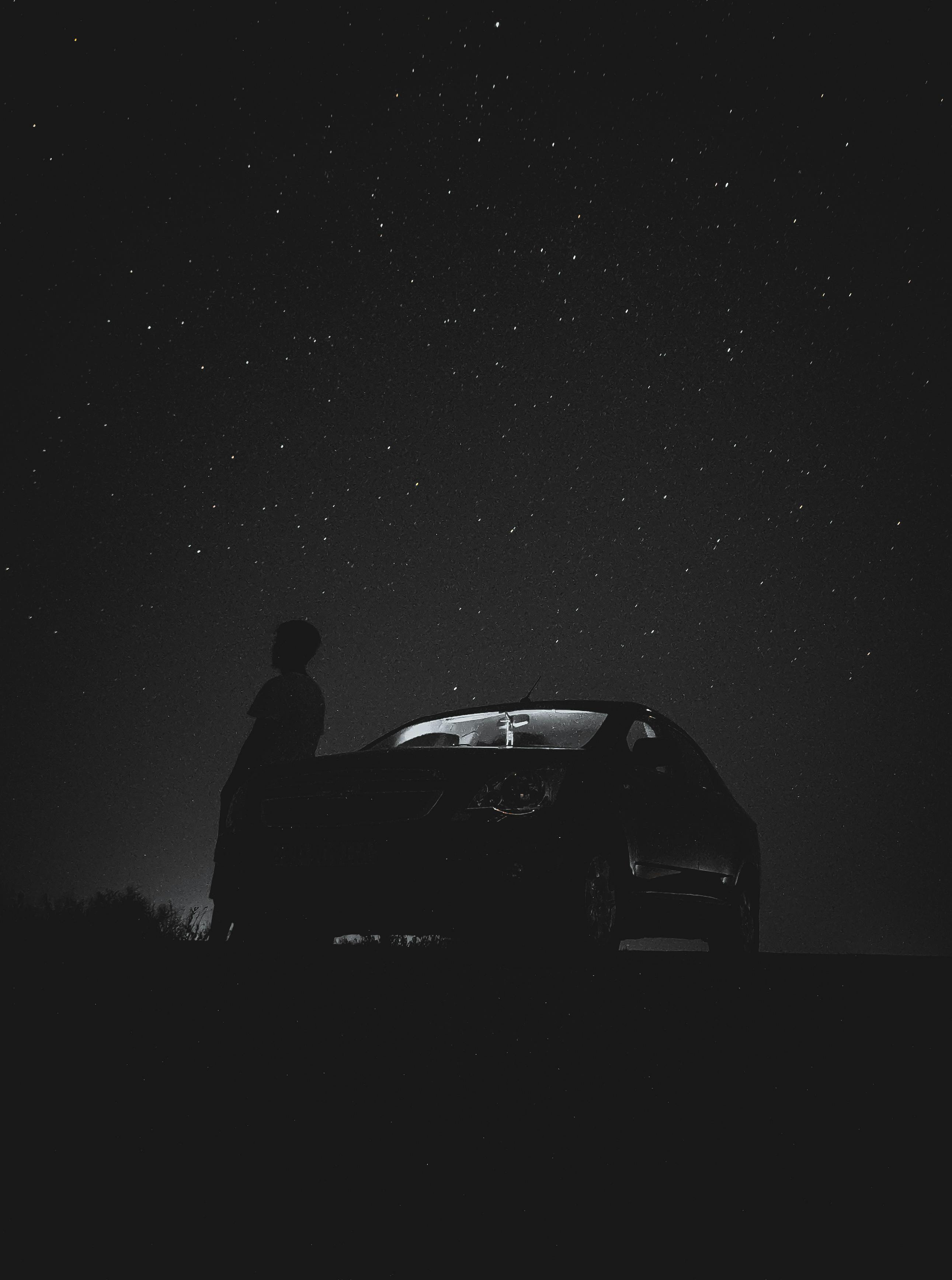 2582x3472 A Person Standing next to a Car at Night · Free