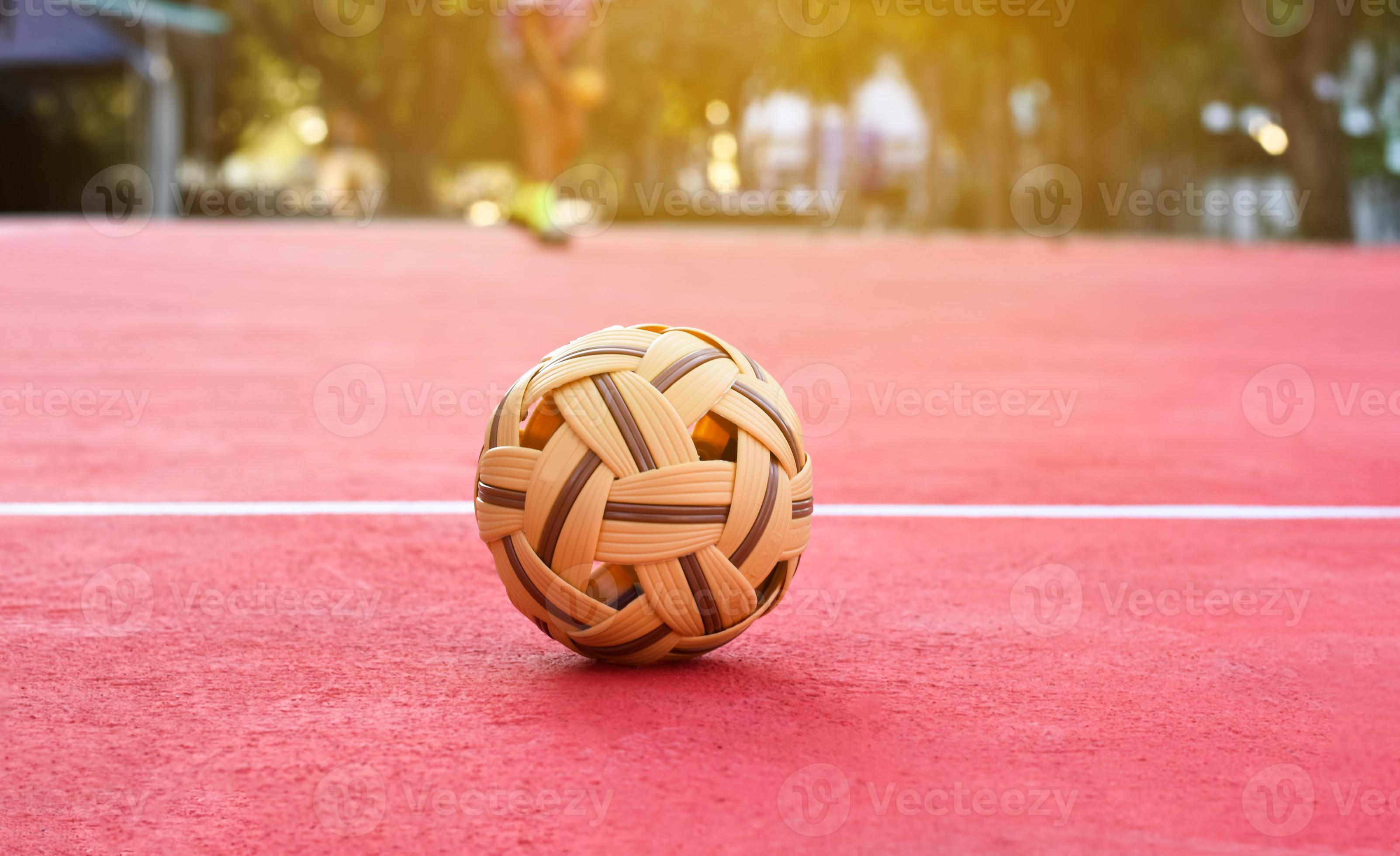 3205x1960 Sepak takraw ball on red floor of outdoor court, blurred background, recreactional activity and outdoor sports in Southeast asian countries concept